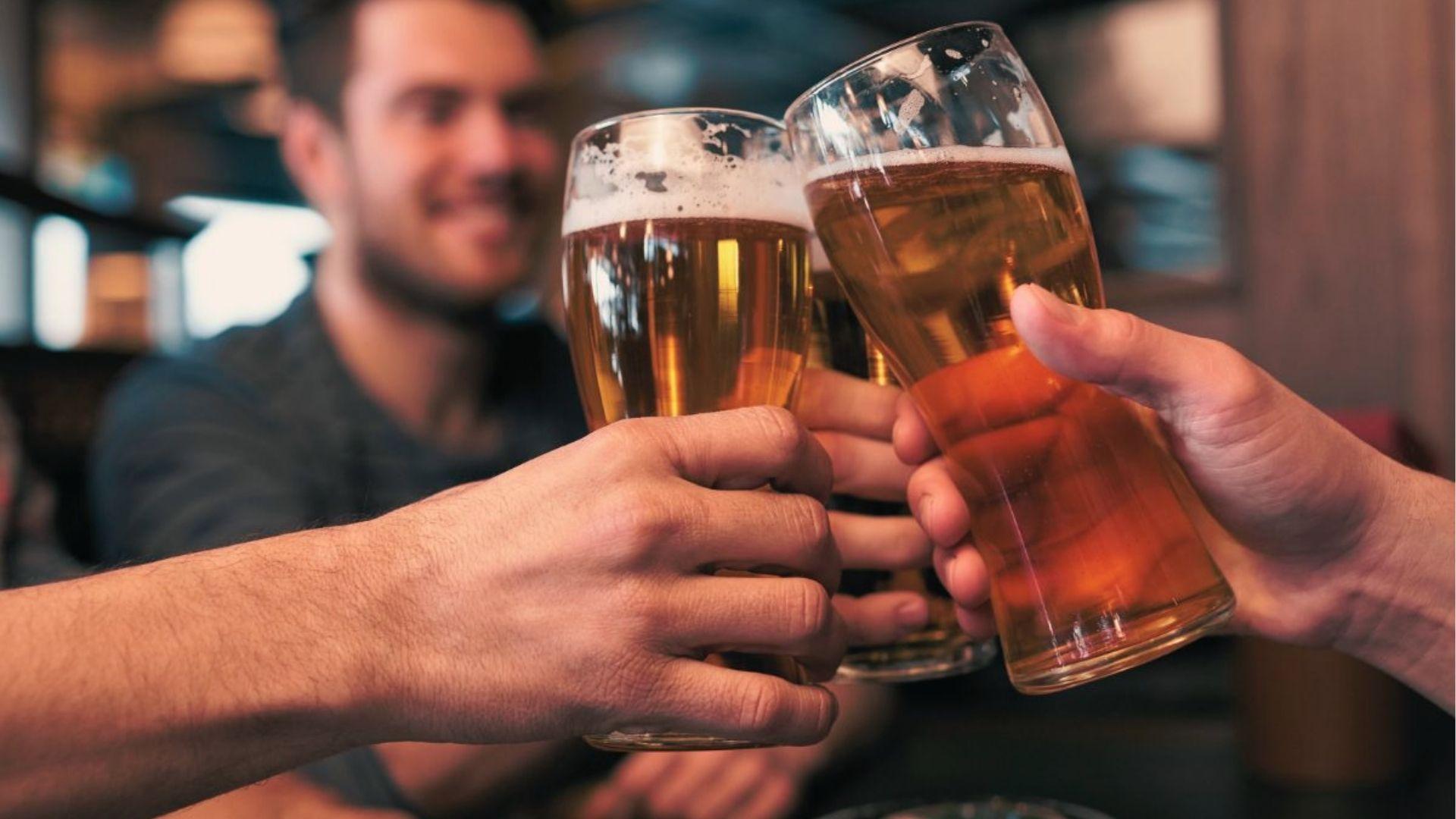Hands raising beer pints in a bar, where Georgia law sets 0.08 BAC as the legal limit for drivers.