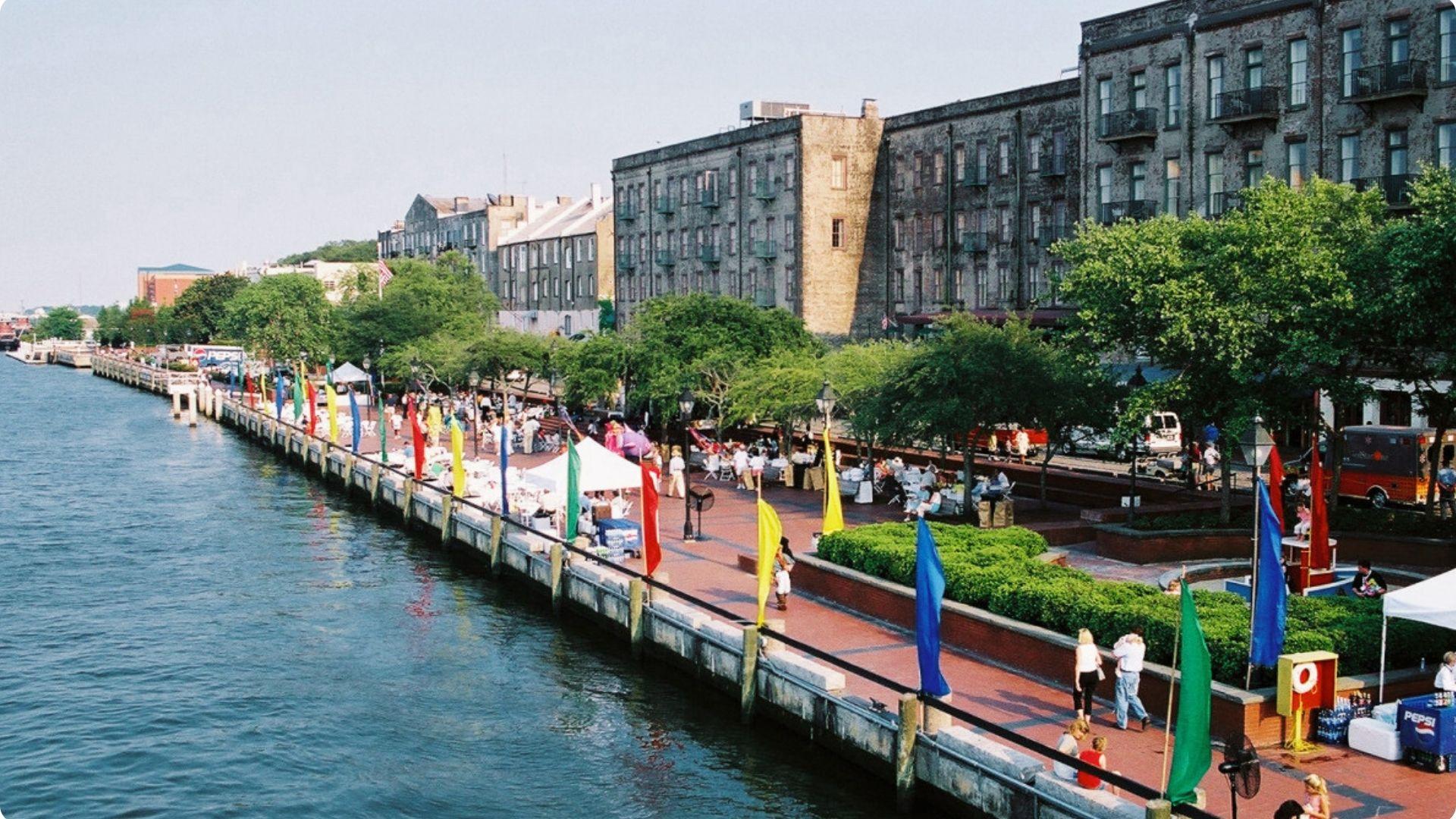 Lively harbourside street with a lot of people and towering buildings spanned throughout the street.