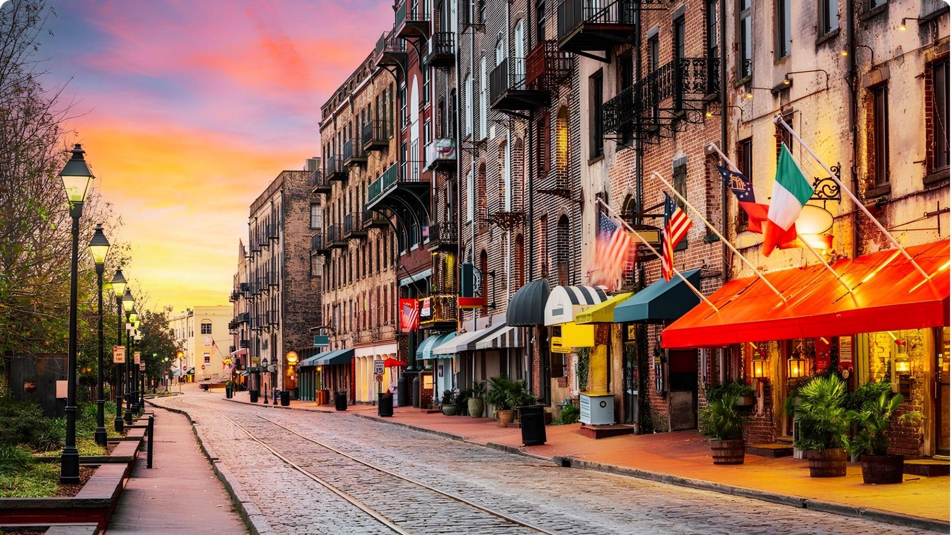 Lively and colourful street market of Savannah, with intimate and local restaurants. Lamp posts along the road compliment the vibrant sunset.