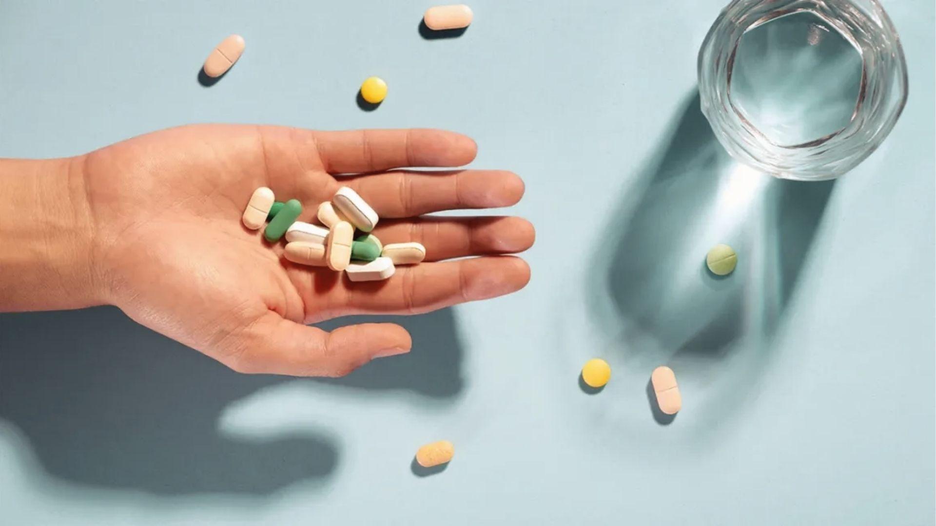 Hand holding assorted pills near water, showing mixing substances can impair driving under Georgia DUI law.