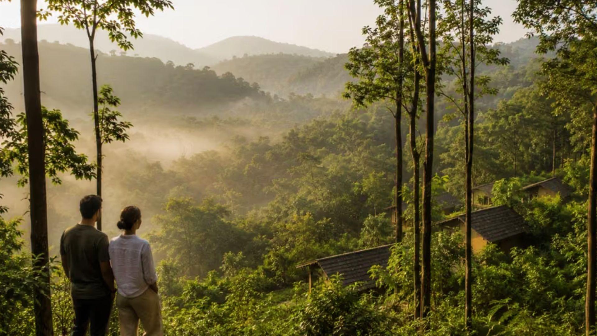 Couple overlooks misty plantation hills and cottages at sunrise, experiencing serene views during a Savannah Plantation Tour getaway.
