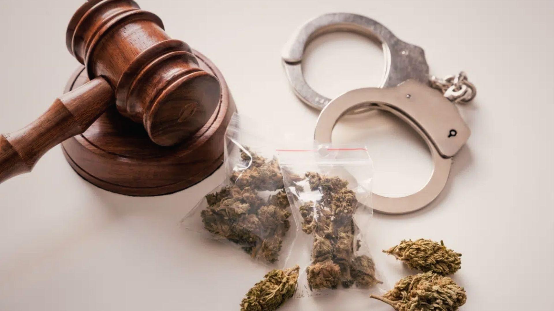 Gavel, handcuffs, and bagged cannabis on white backdrop tied to synthetic marijuana laws in Georgia.