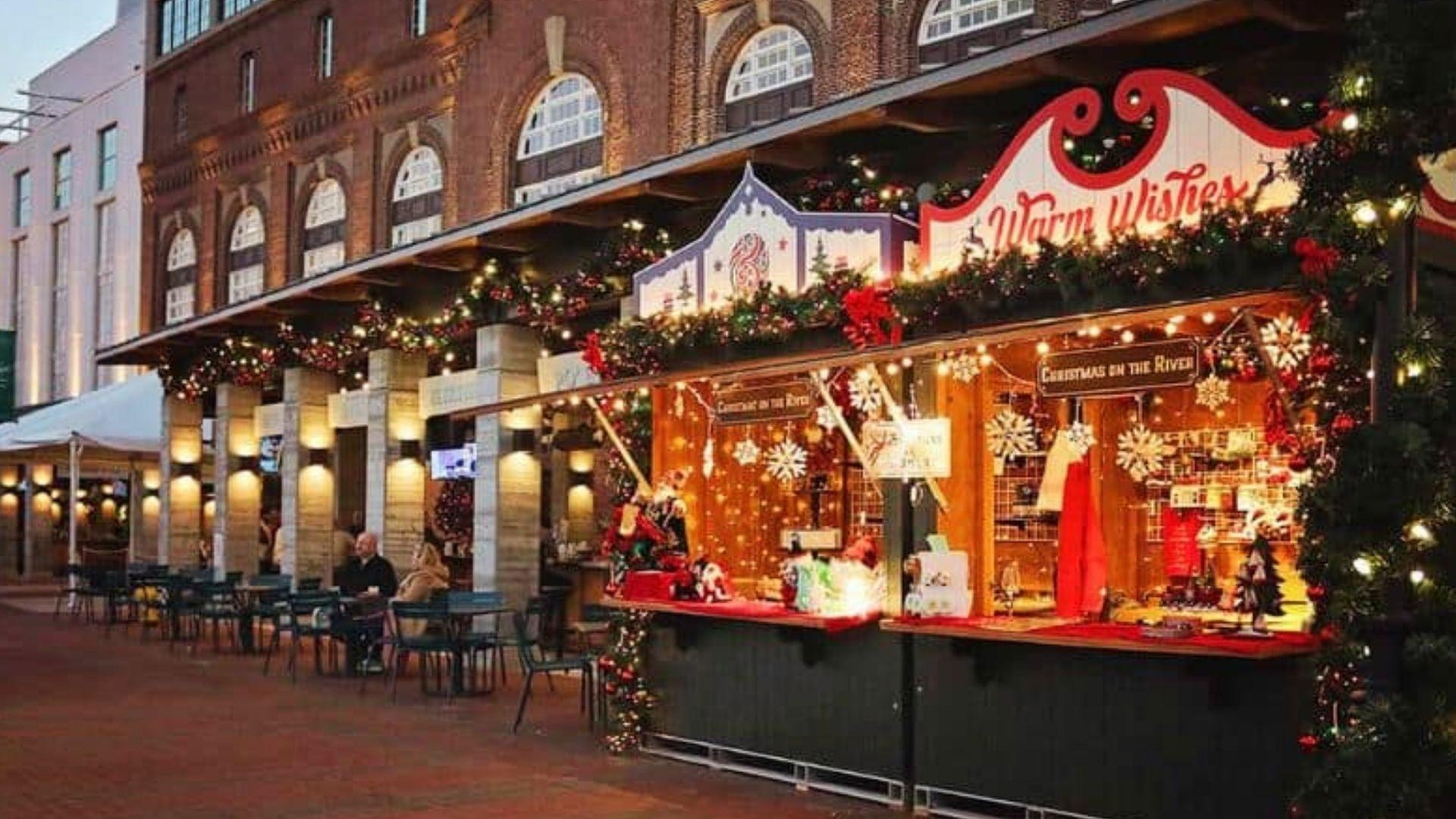 Warm Wishes Christmas on the River market stall in Savannah with twinkle lights, snowflakes, and holiday gifts displayed
