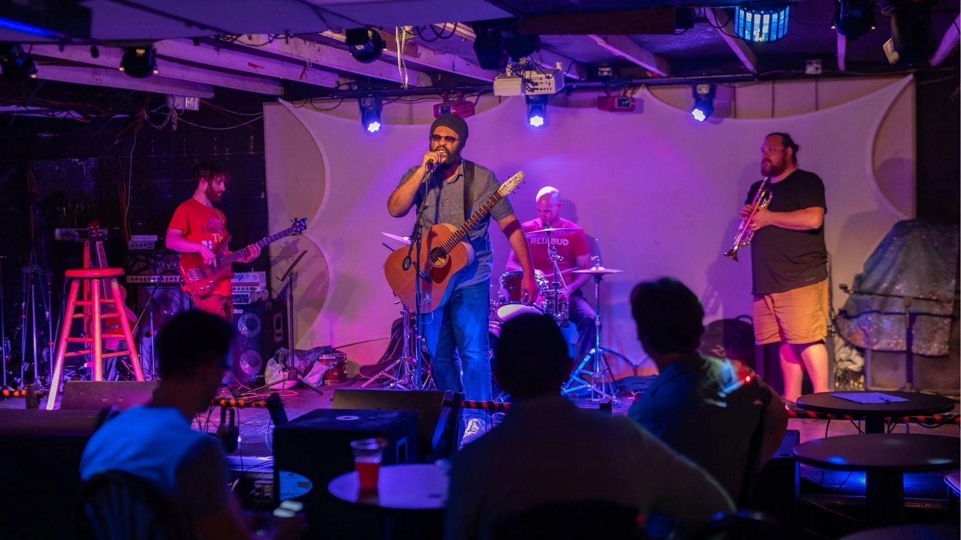 IMAGE OF A BAND PERFORMING IN FRONT OF AUDIENCE