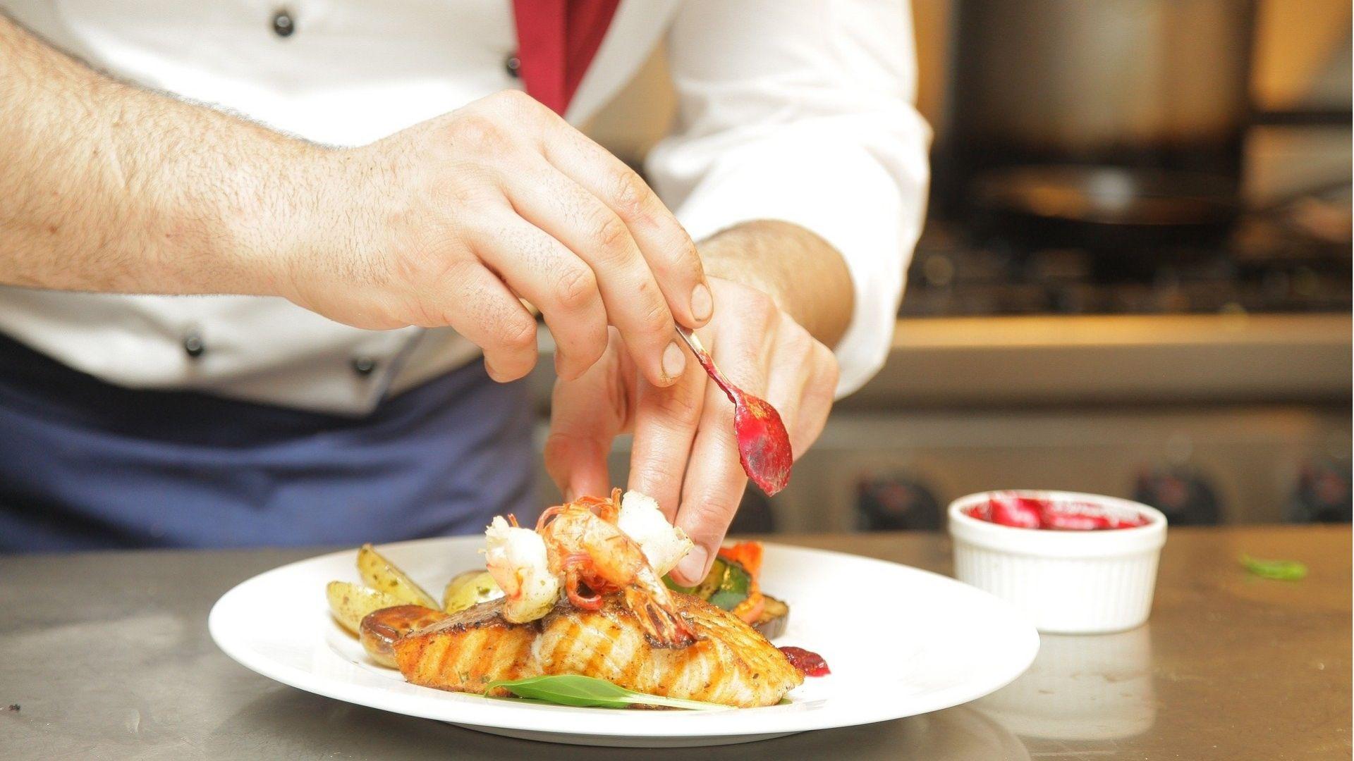 IMAGE OF A CHEF PREPARING HIS DISH FOR TASTING