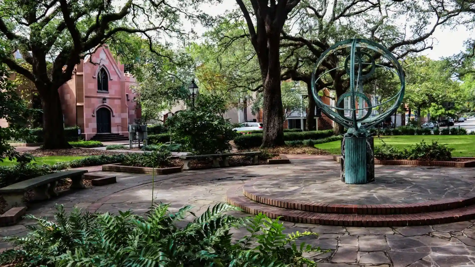 Bronze armillary sphere monument in Wright Square with Lutheran Church of the Ascension behind.