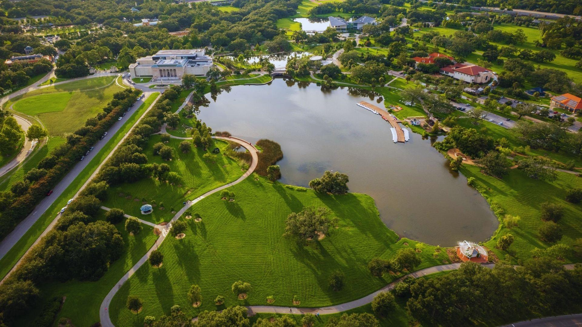 Aerial view of City Park with lagoon, walking paths, New Orleans Museum of Art, trees, bridges, green lawns