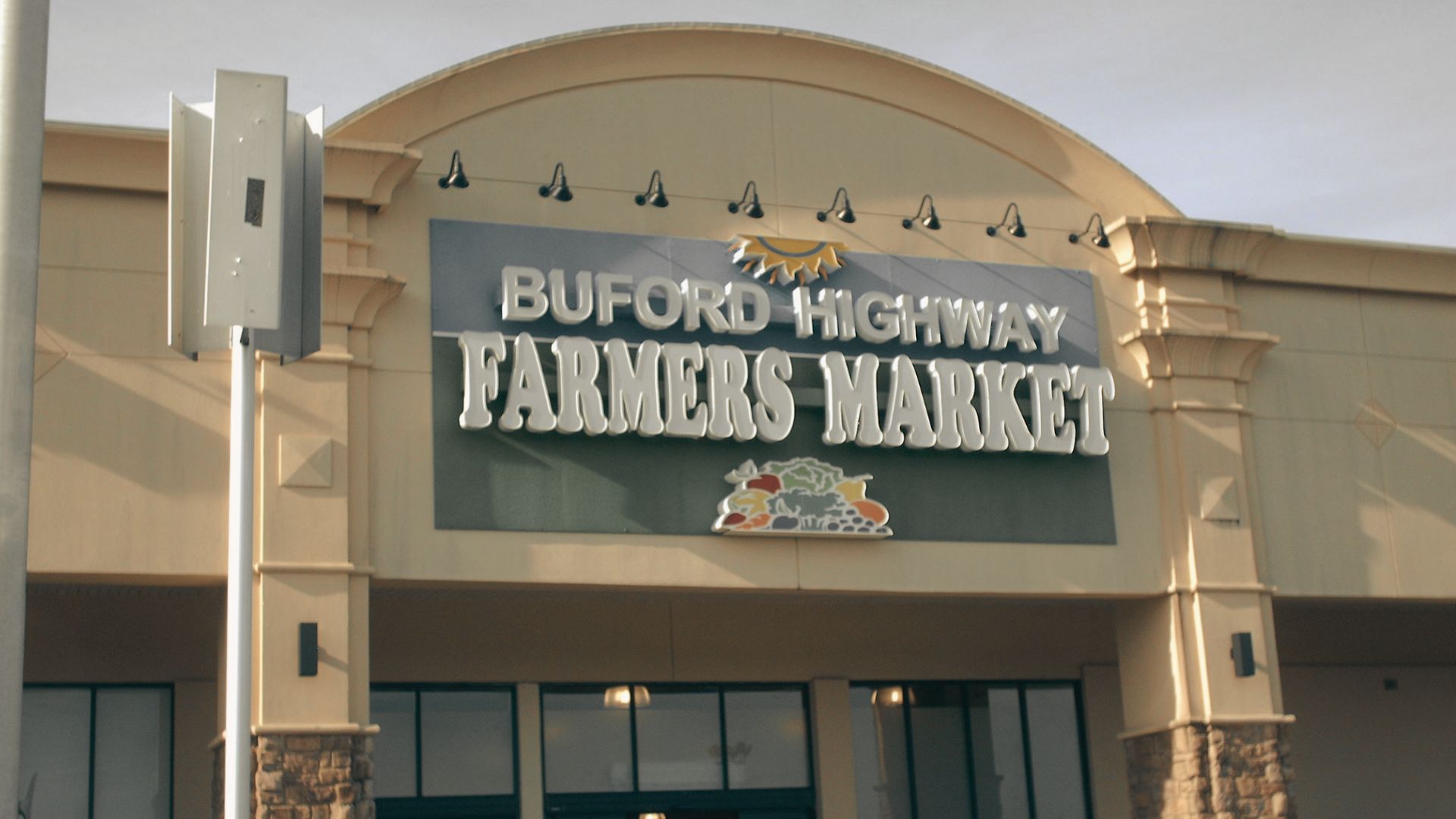 Front entrance of Buford Highway Farmers Market with a large sign above covered shopping center entrance.