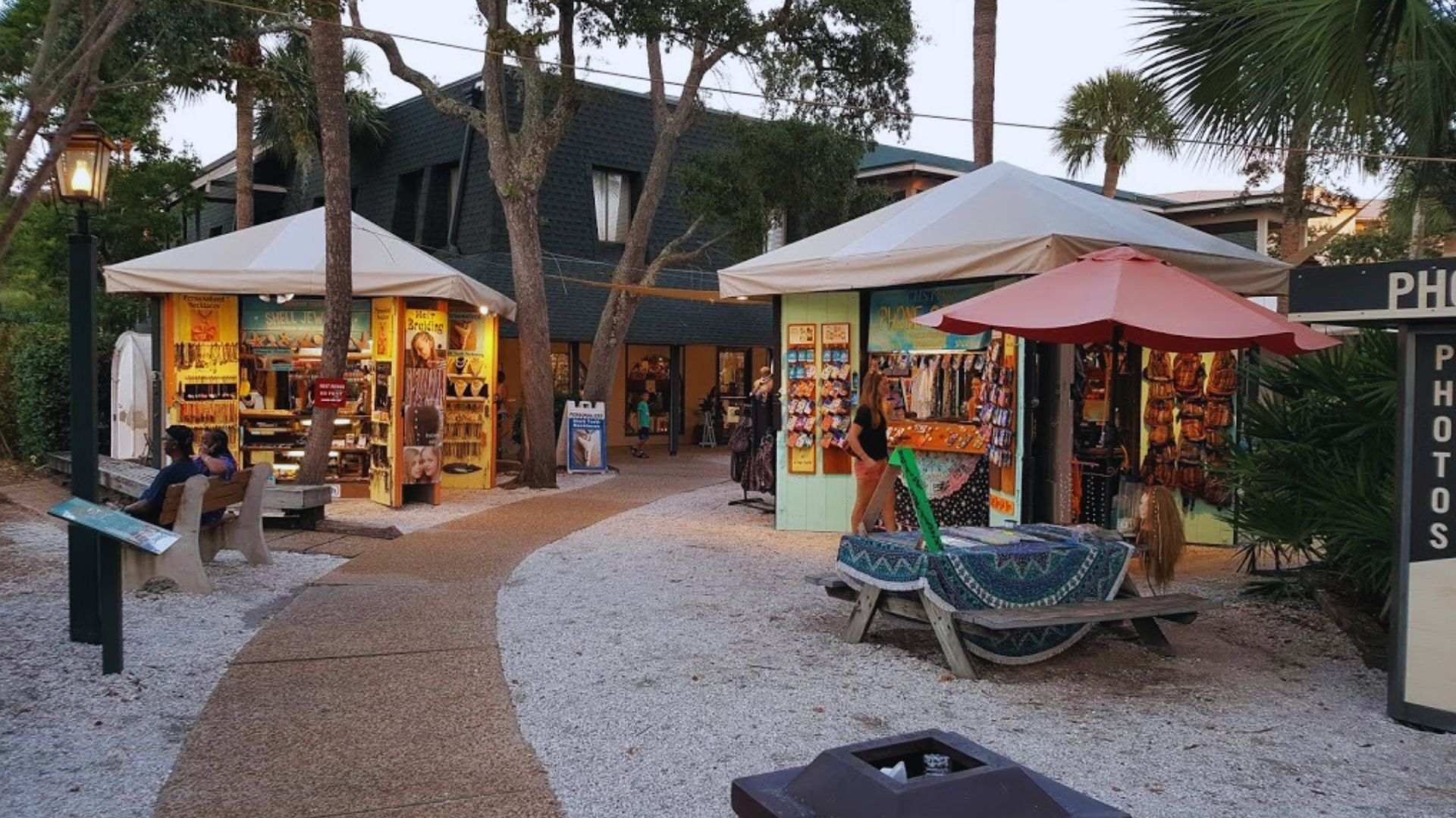 Outdoor market stalls under tents among palm trees at Coligny Plaza.
