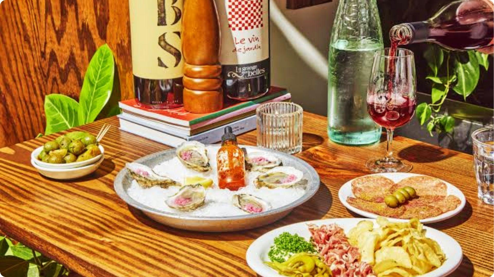 Oysters wine and charcuterie on wooden table showcasing best dinner savannah ga seafood and wine bar