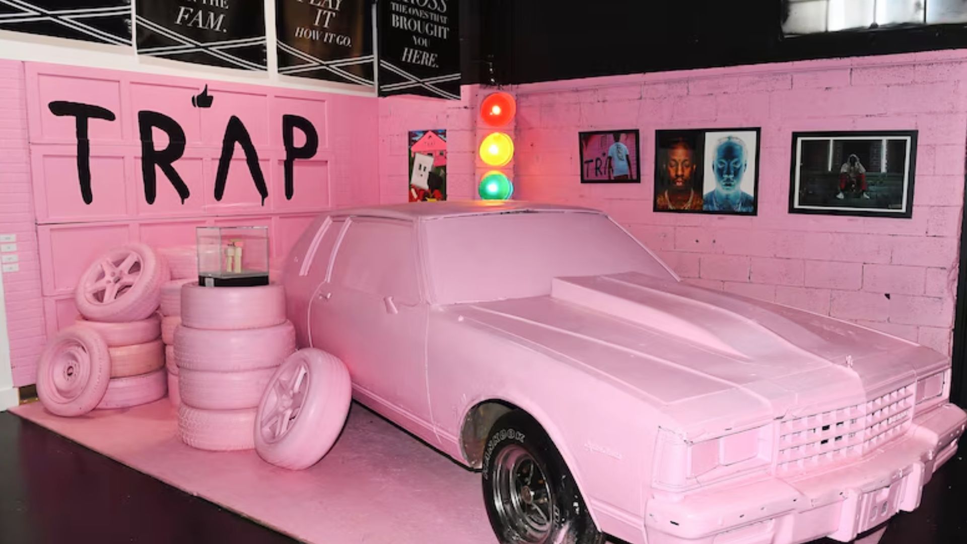 Pink car installation and tire display inside Atlanta's Trap Music Museum featuring hip hop inspired artwork.