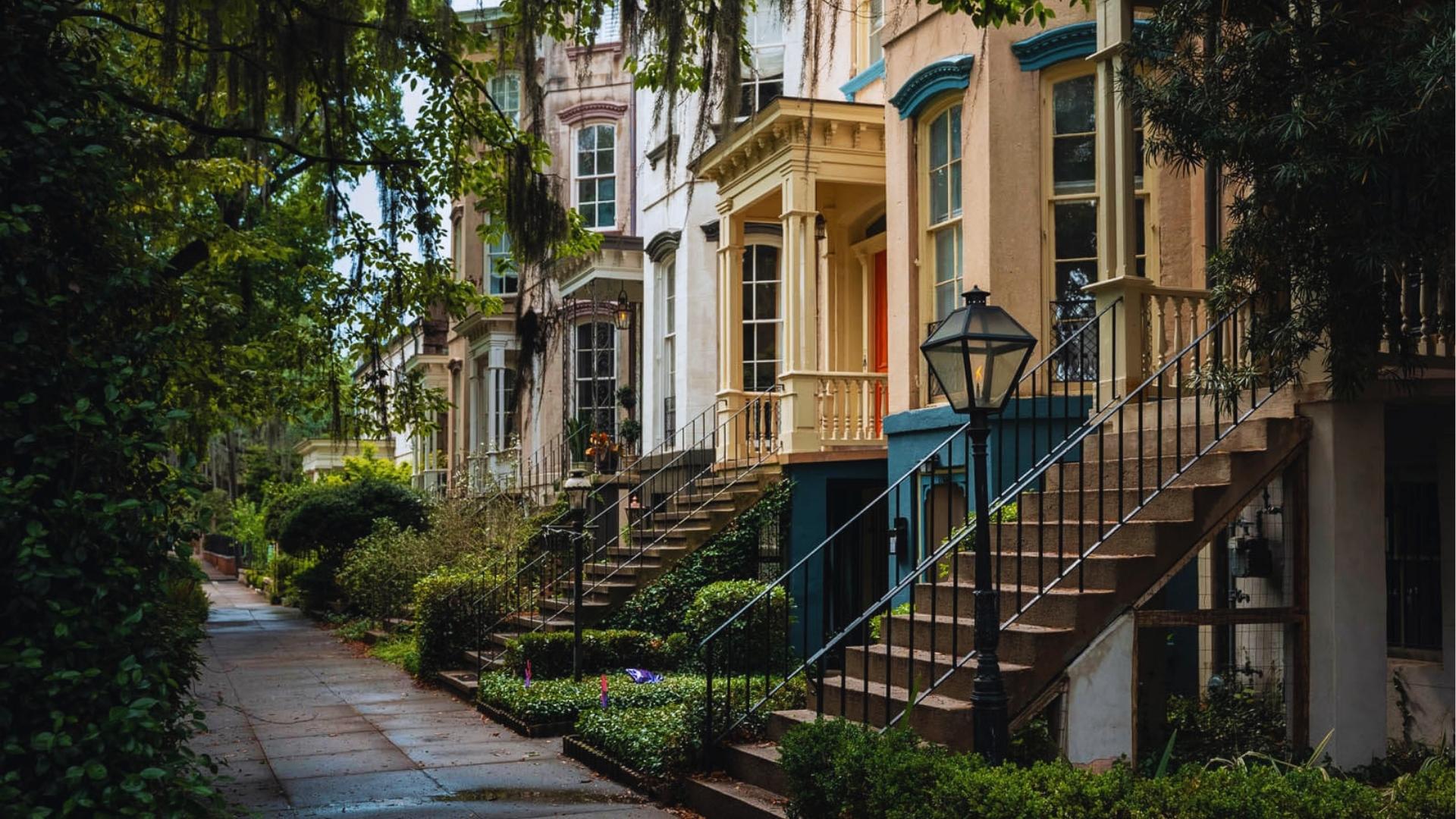 Colorful historic townhouses with staircases on Jones Street in Savannah's Historic District.