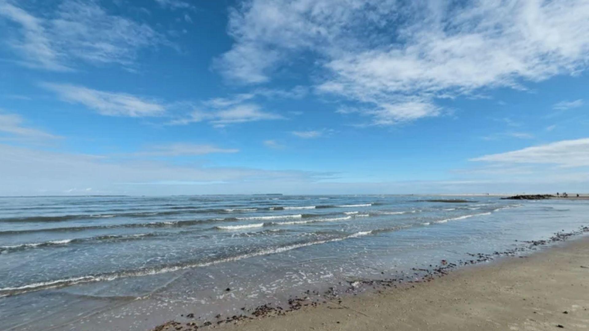 Calm waves at Butterbean Beach Savannah GA under blue sky