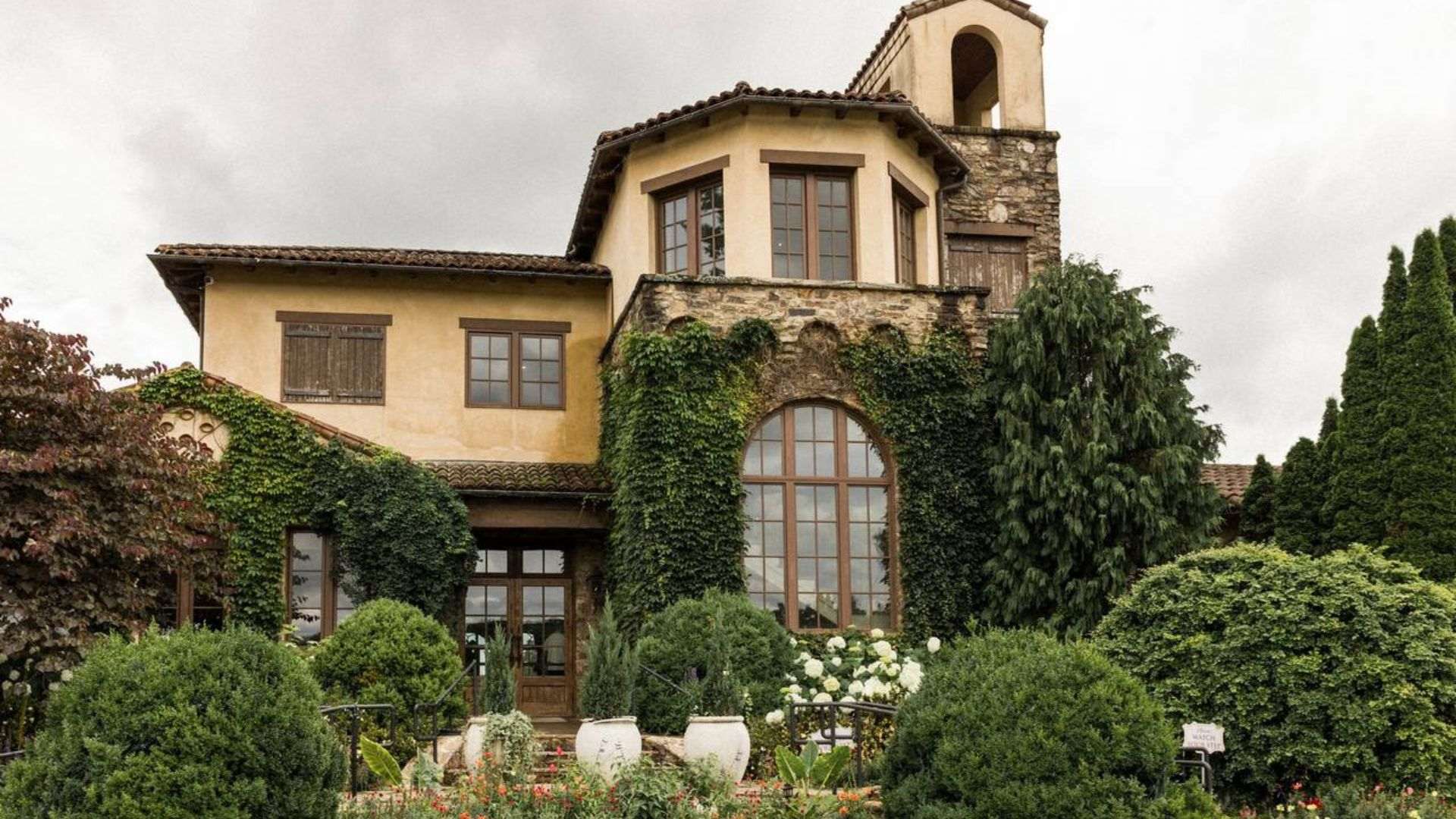 A picturesque house with a garden and trees at Montaluce Winery, offering a serene atmosphere for guests to enjoy.