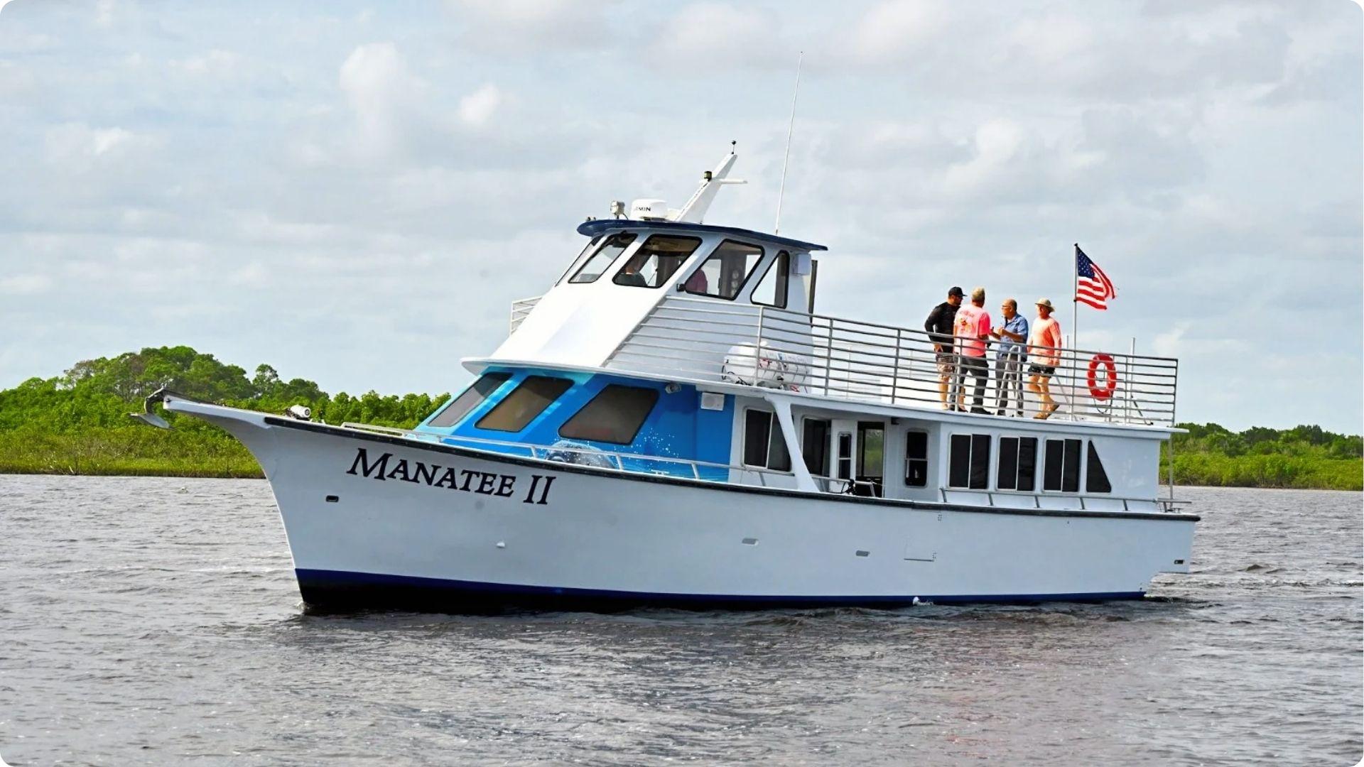 Manatee II tour boat heading to Daufuskie Island with guests on upper deck and marsh shoreline