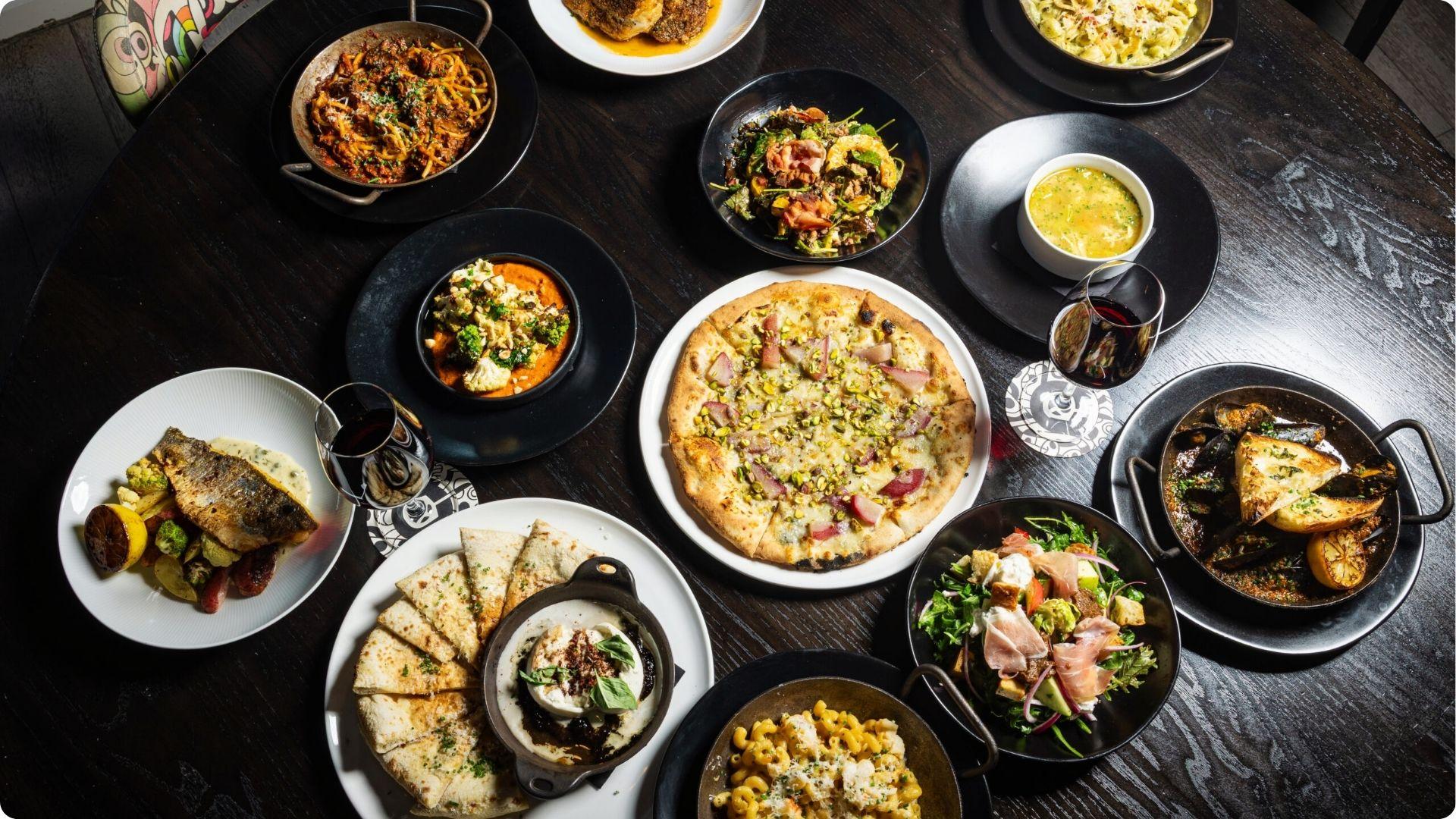Wood-fired pizza pasta and fresh seafood flatlay capturing authentic best dinner savannah ga restaurant scene