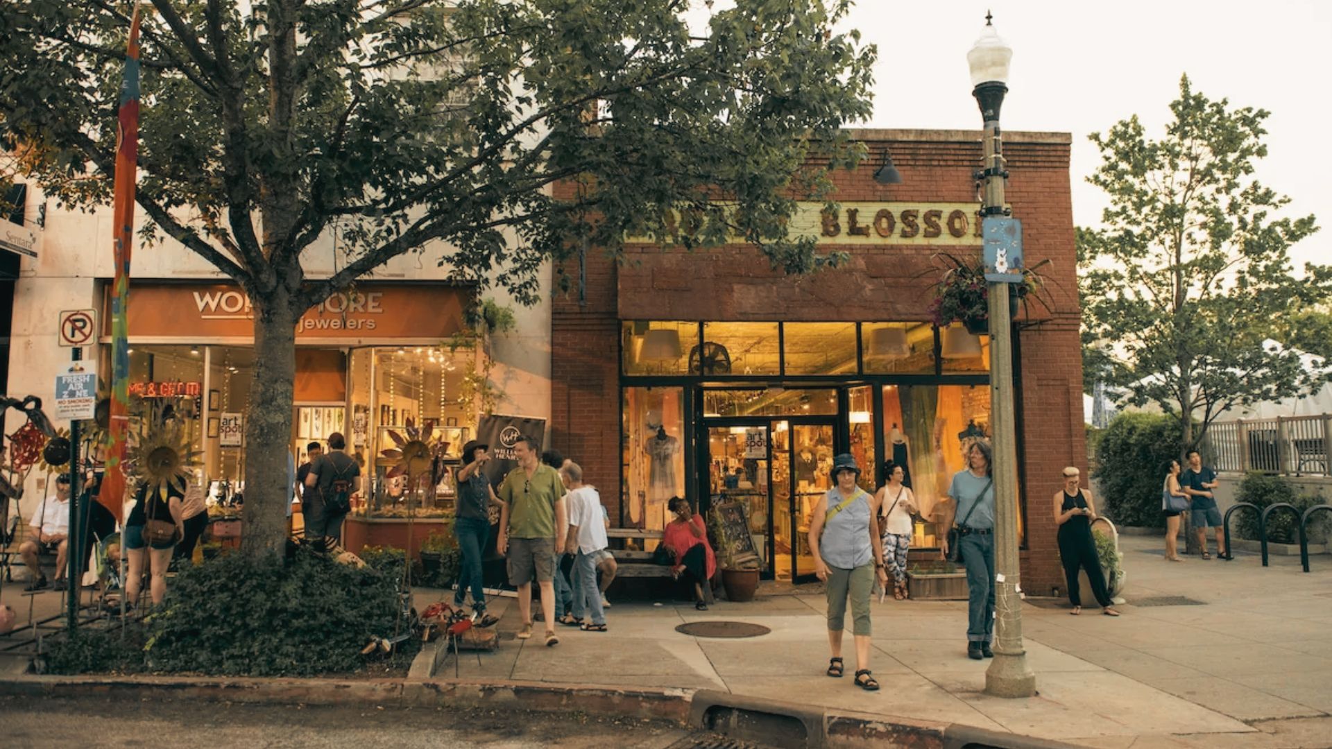 People walk outside Blossom and nearby shops along a tree lined street in Decatur.