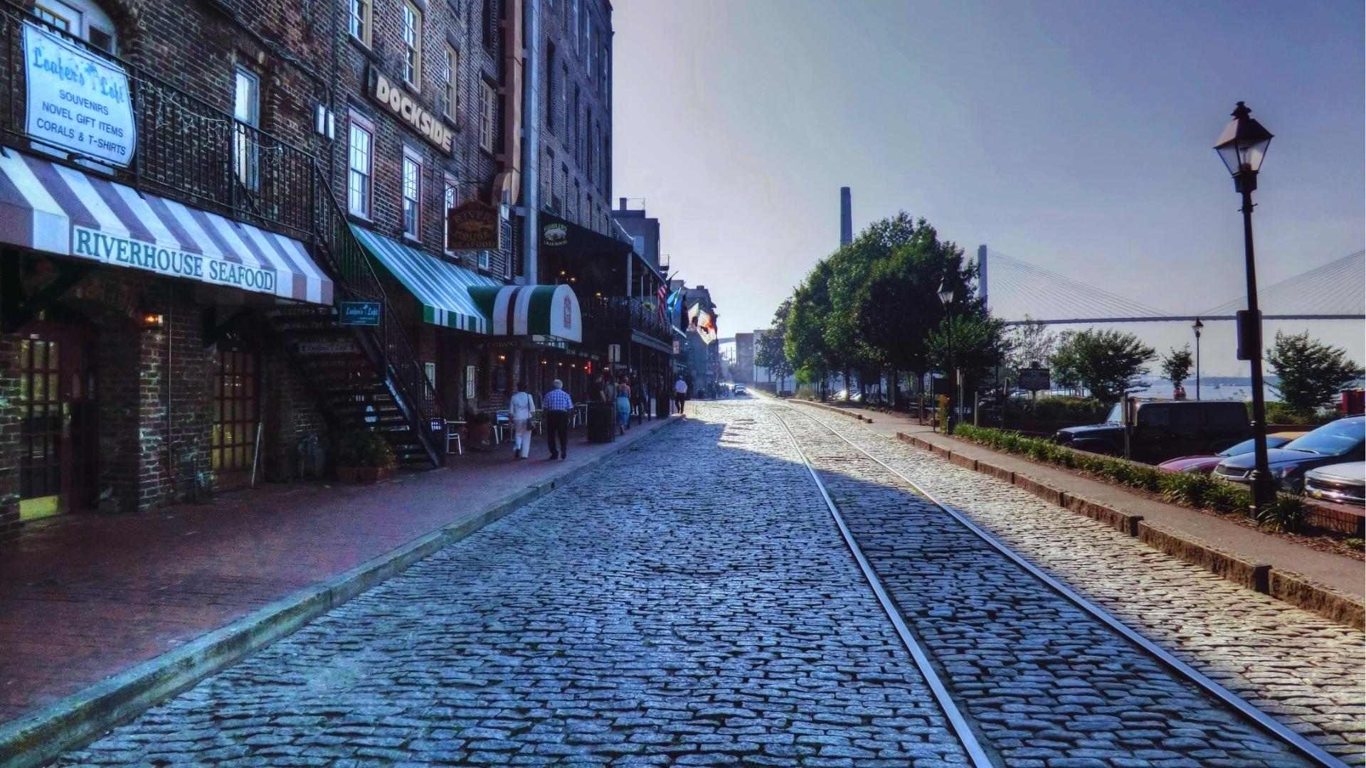 Cobblestone River Street with Riverhouse Seafood restaurant and Talmadge Bridge view in Savannah.
