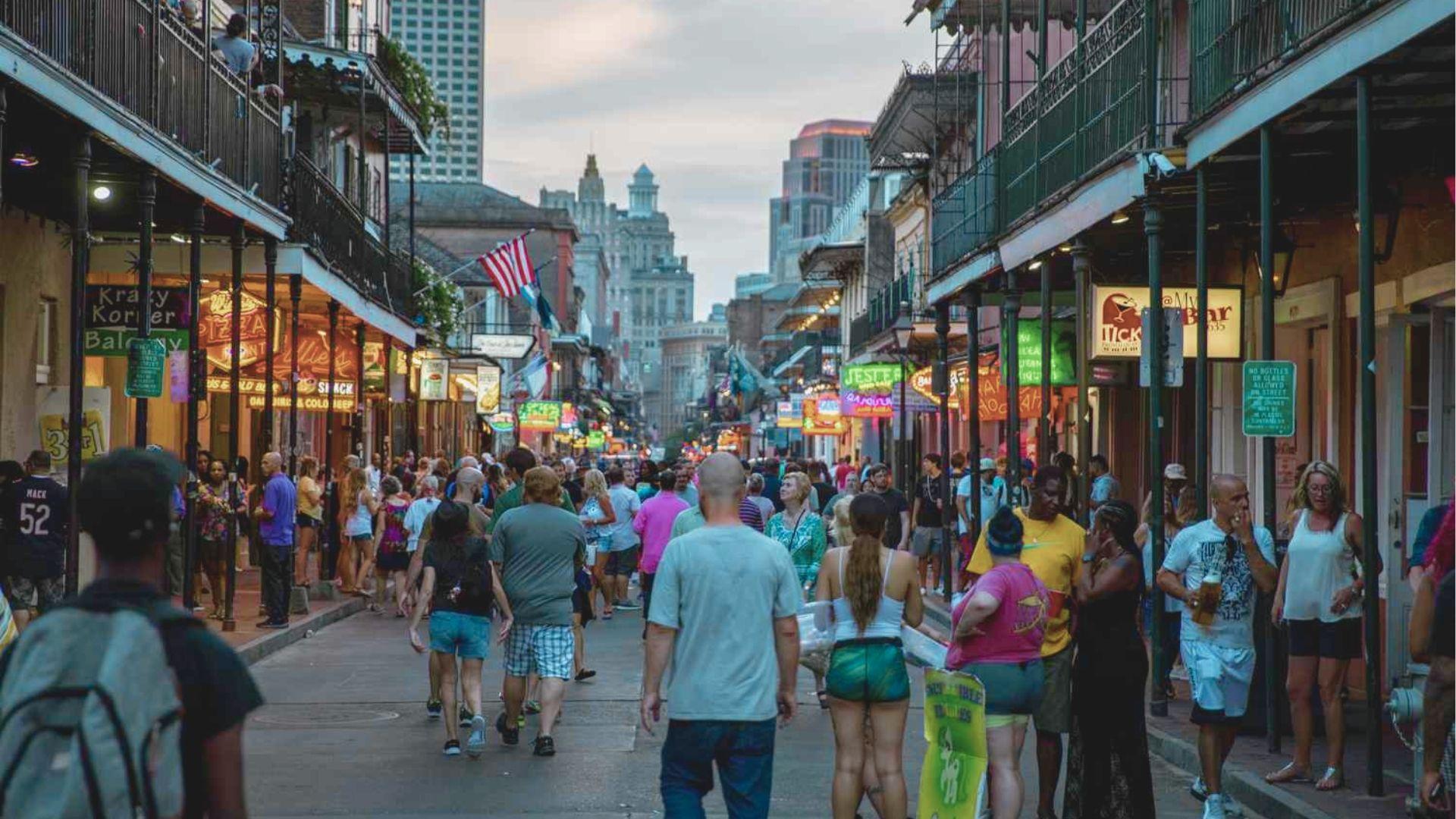 Experience Bourbon Street at dusk, alive with neon signs, jazz bars, and bustling crowds.