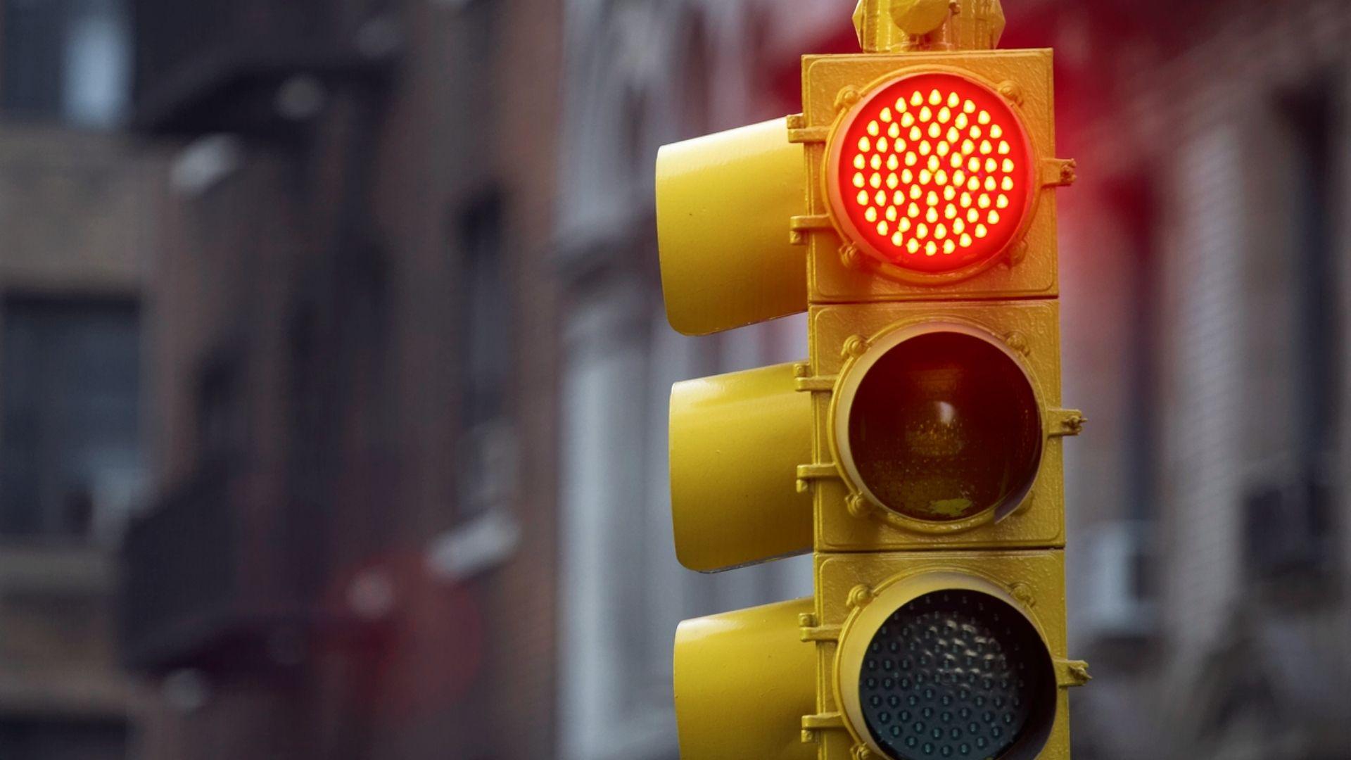 Close-up of illuminated red traffic light on city street showing Georgia law requires drivers to stop completely before right turn on red