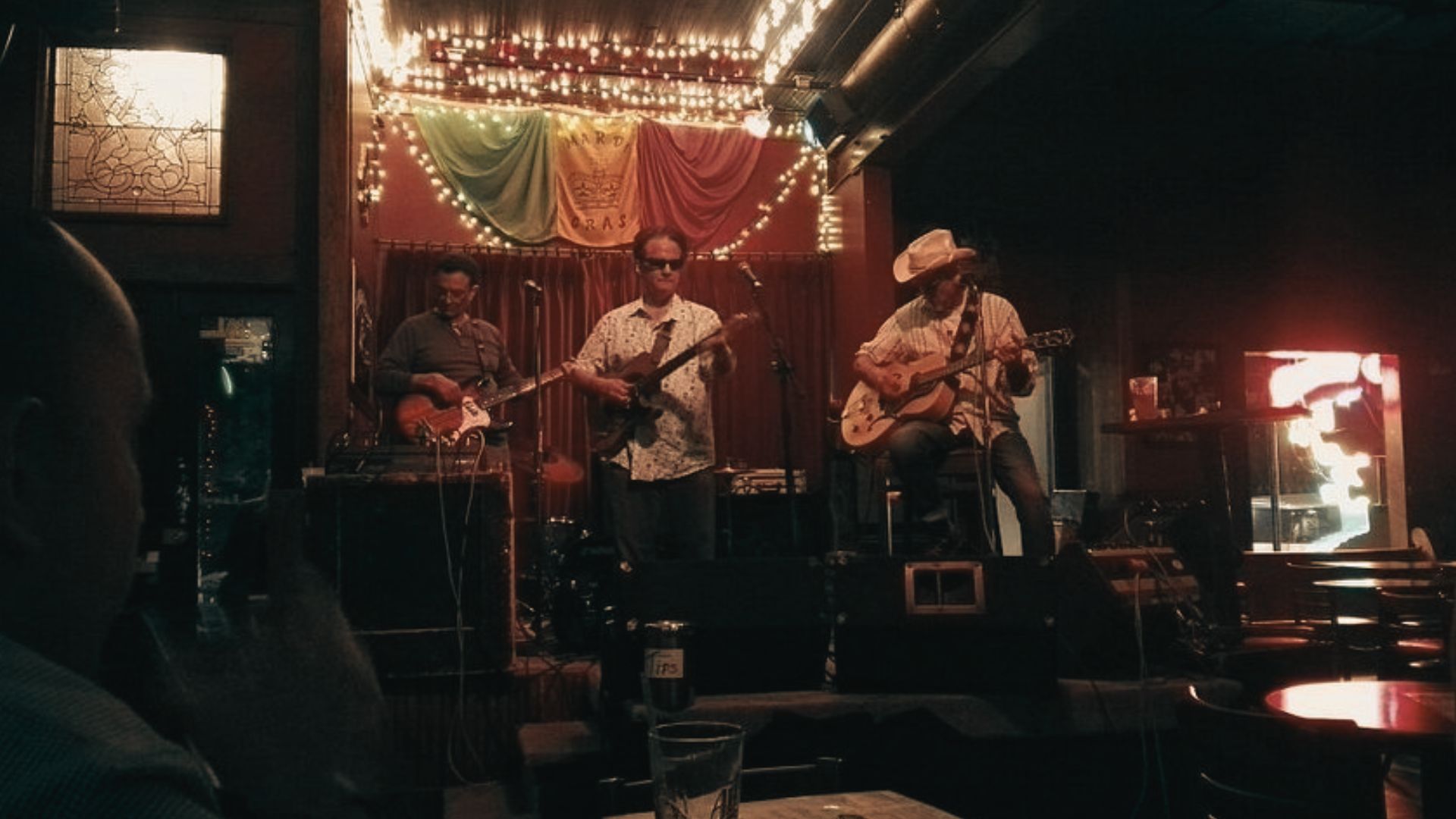 Musicians perform live jazz at Blind Willie's under warm lights on the stage.