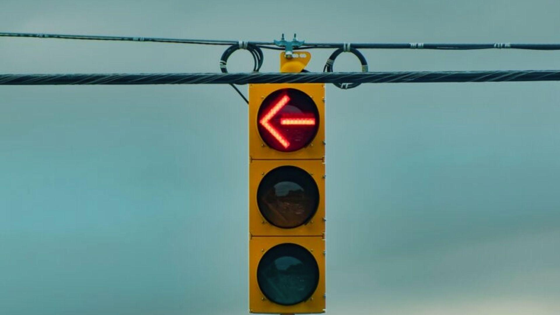 Red traffic light against blue sky representing Georgia law requiring full stop before turning right on red