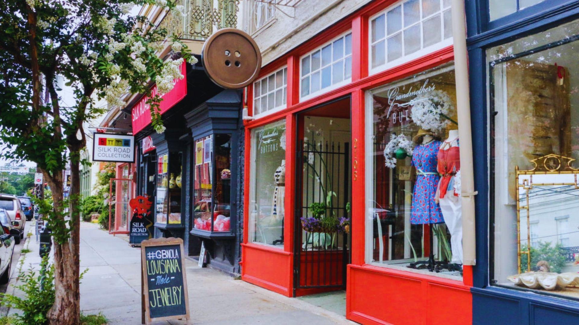 Magazine Street shops with red storefront, giant button sign, Grandmother’s Buttons window display, Louisiana jewelry sidewalk sign