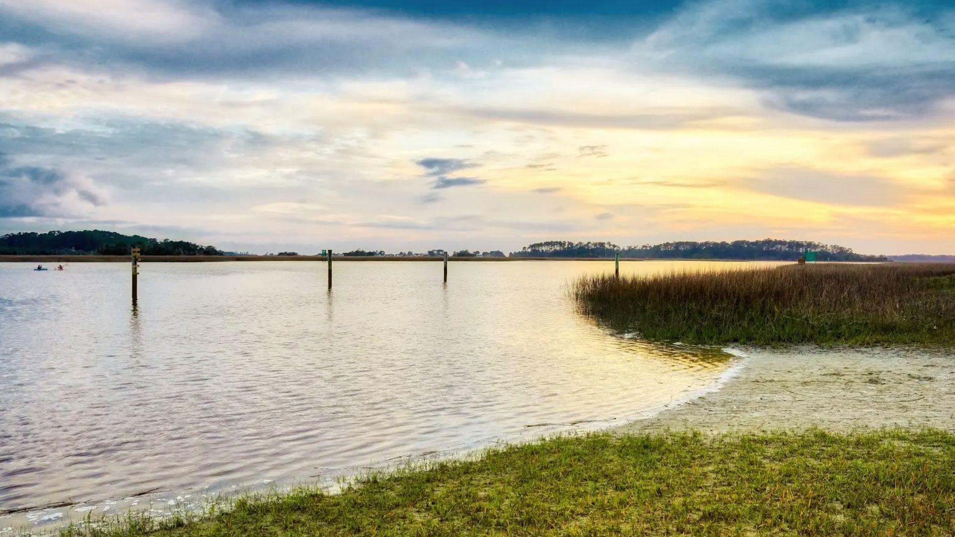 Golden sunset over Butterbean Beach marsh with kayakers