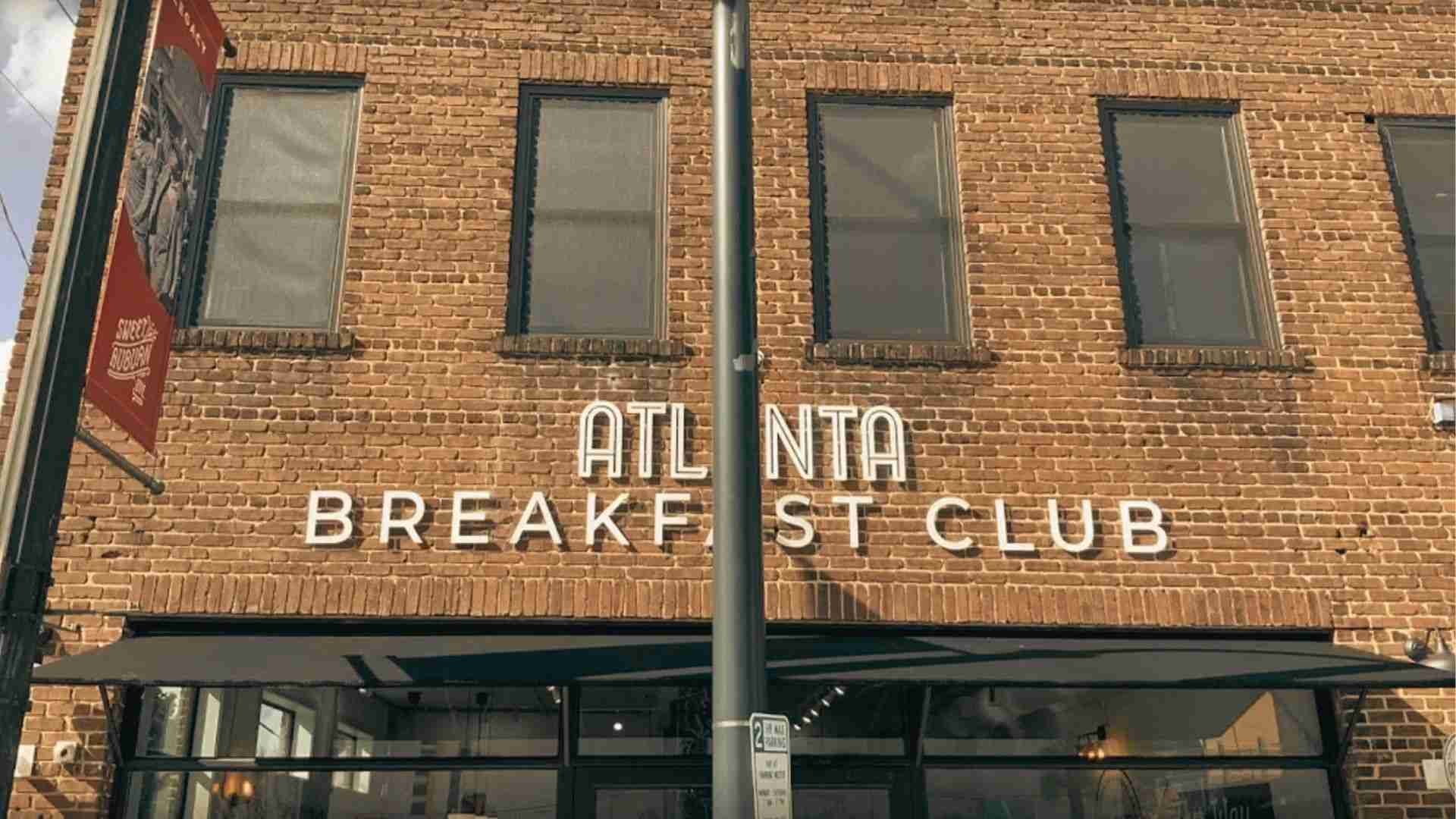 Exterior of Atlanta Breakfast Club storefront with brick facade and illuminated signage.