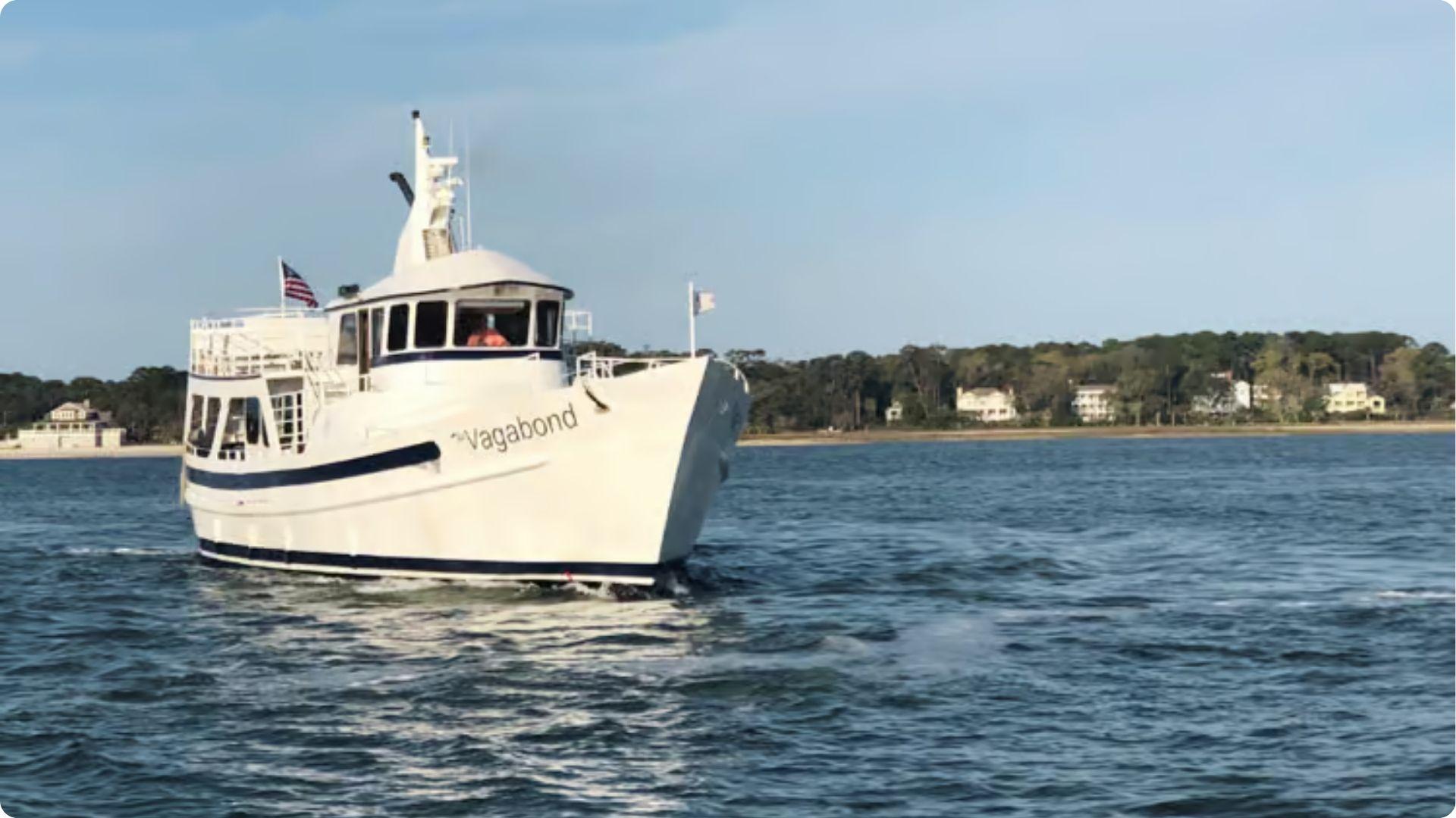 The Vagabond ferry cruising to Daufuskie Island across calm waters with shoreline homes behind