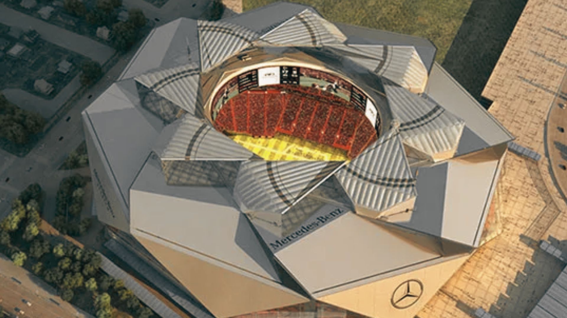Aerial view of Mercedes Benz Stadium showcasing retractable roof design and illuminated football field interior.