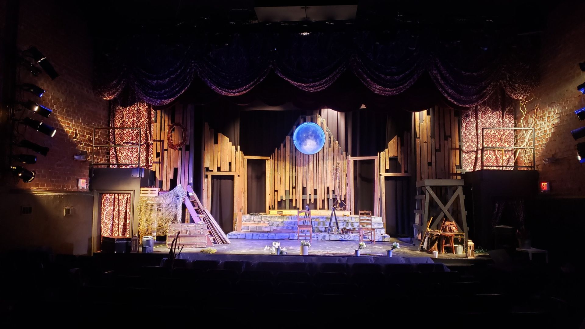 A stage set for a performance at the Historic Holly Theater, featuring a large clock as a focal point.