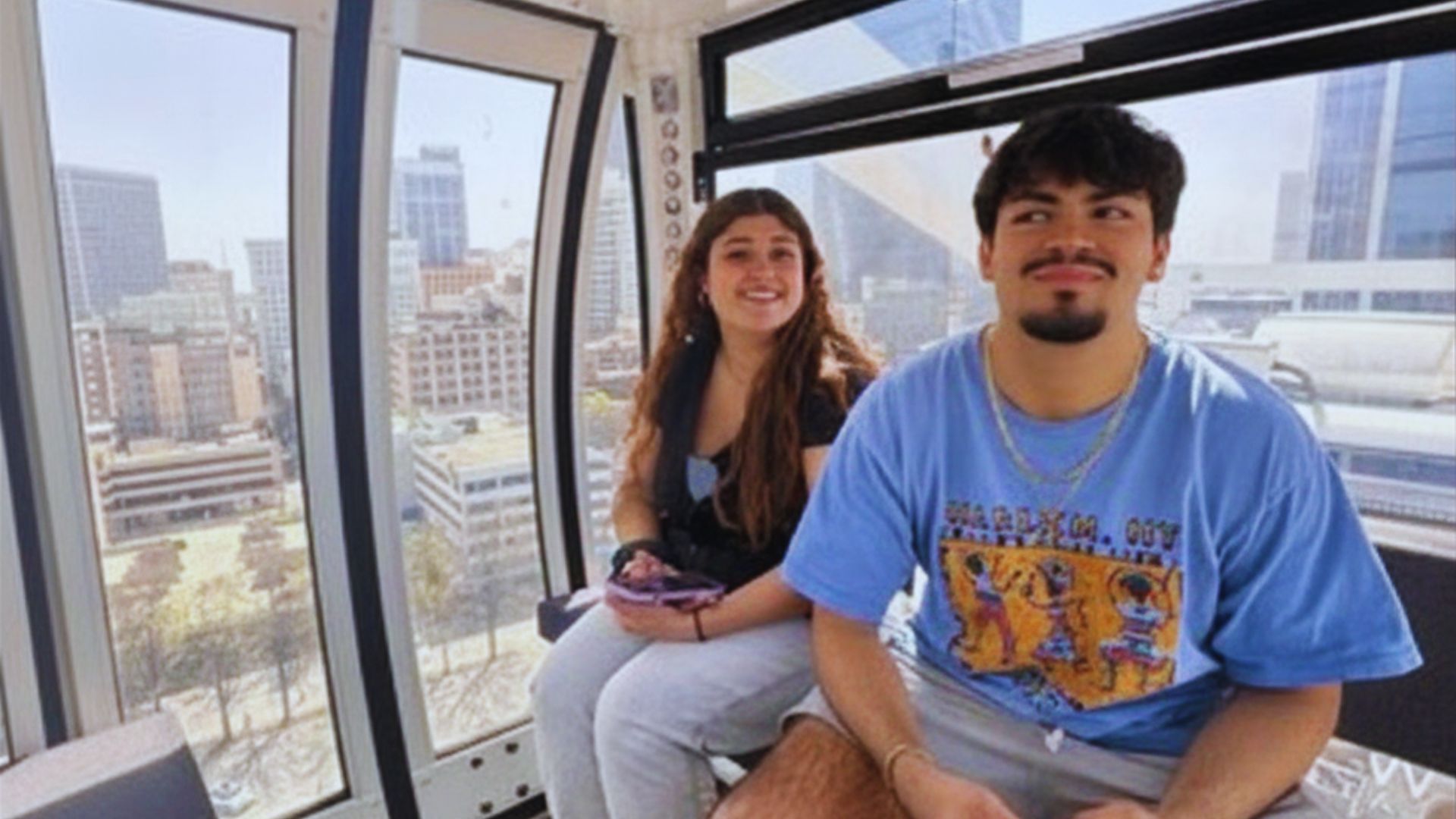 Visitors enjoy panoramic downtown Atlanta views from inside a climate controlled SkyView Atlanta gondola cabin.