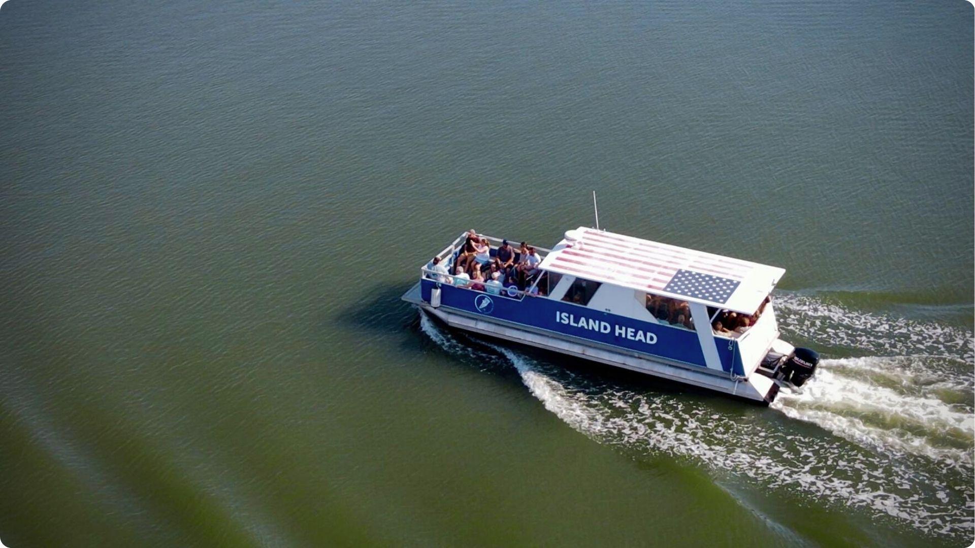 Aerial view of Island Head ferry carrying passengers to Daufuskie Island over green coastal waters