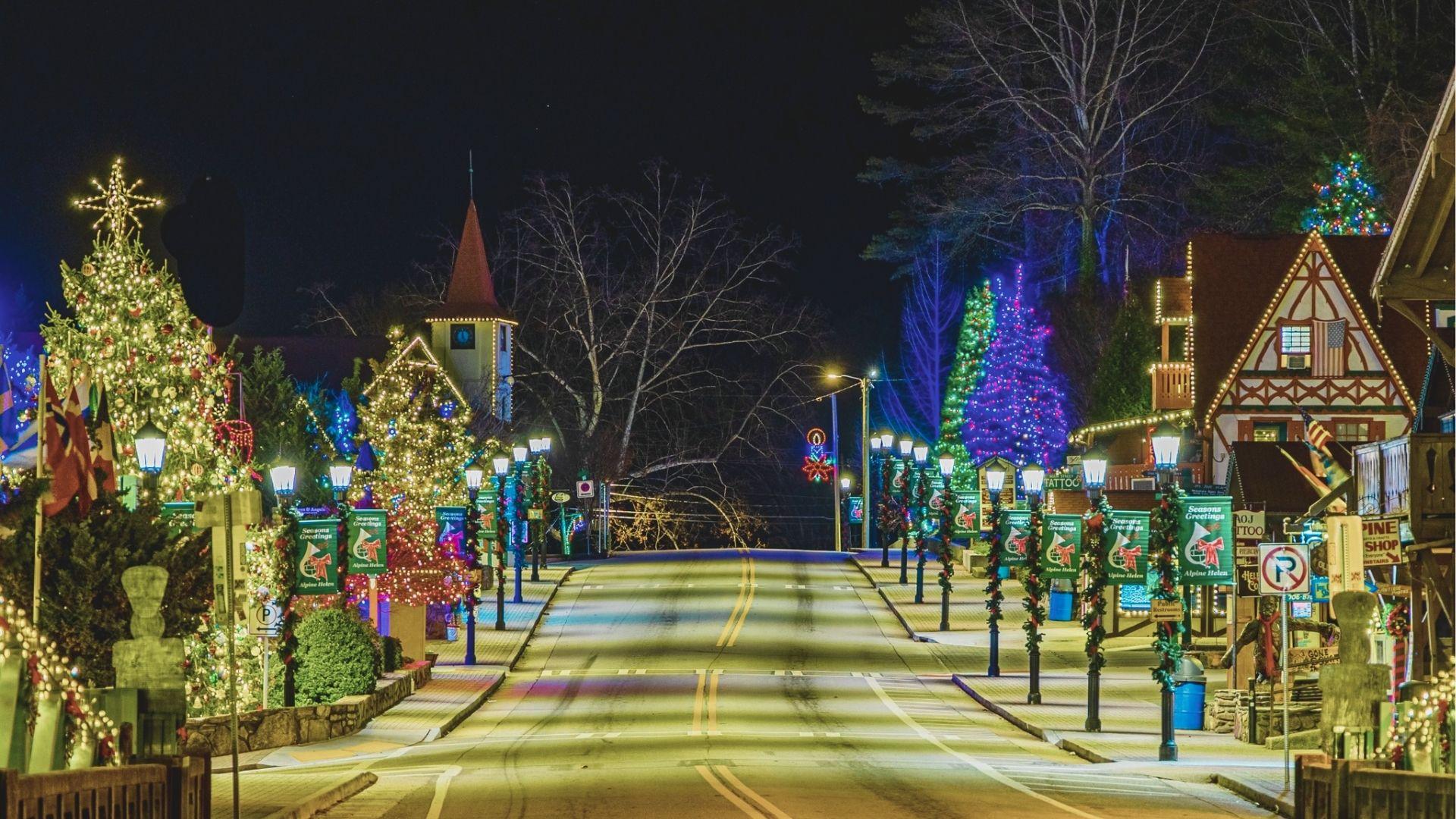 Helen’s Main Street at night lined with towering Christmas trees wrapped in thousands of white and colored lights.