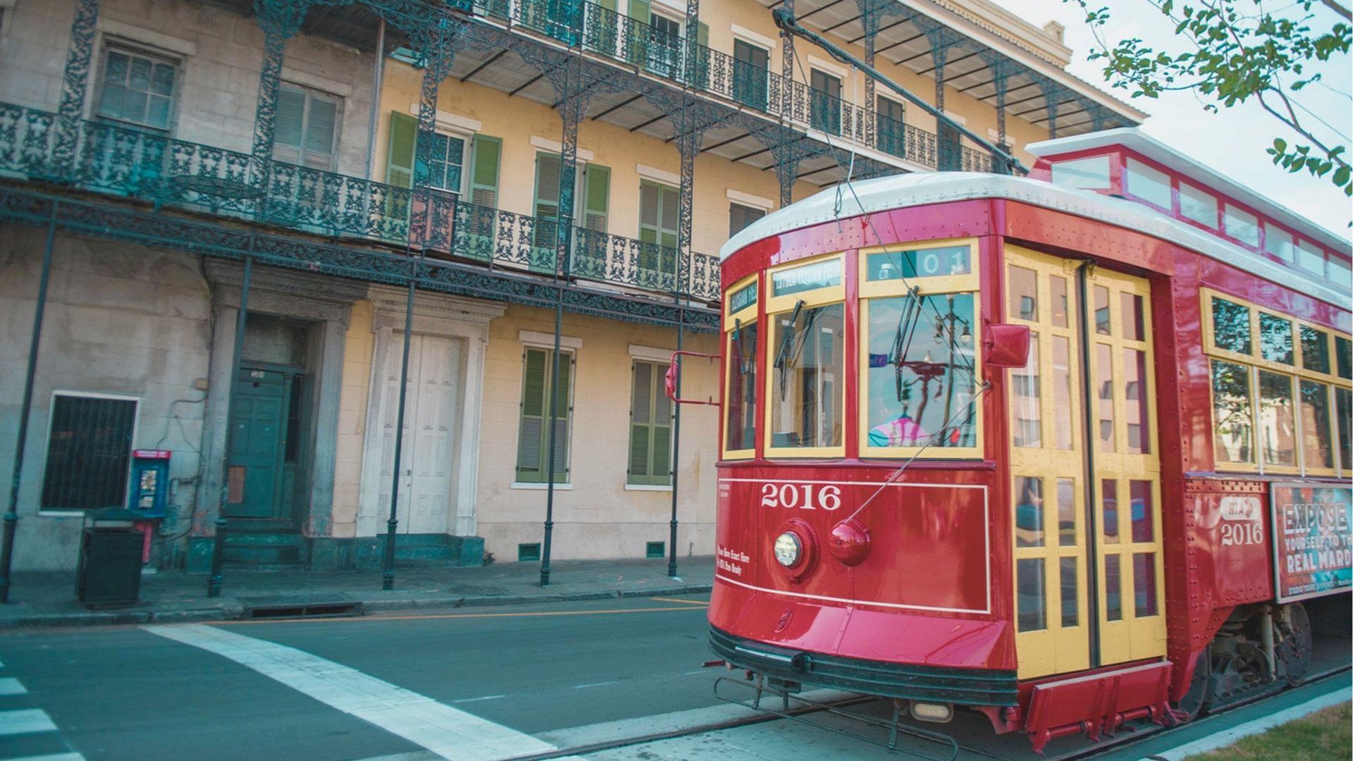 Ride the historic red streetcar past ornate French Quarter balconies with classic wrought-iron railings.