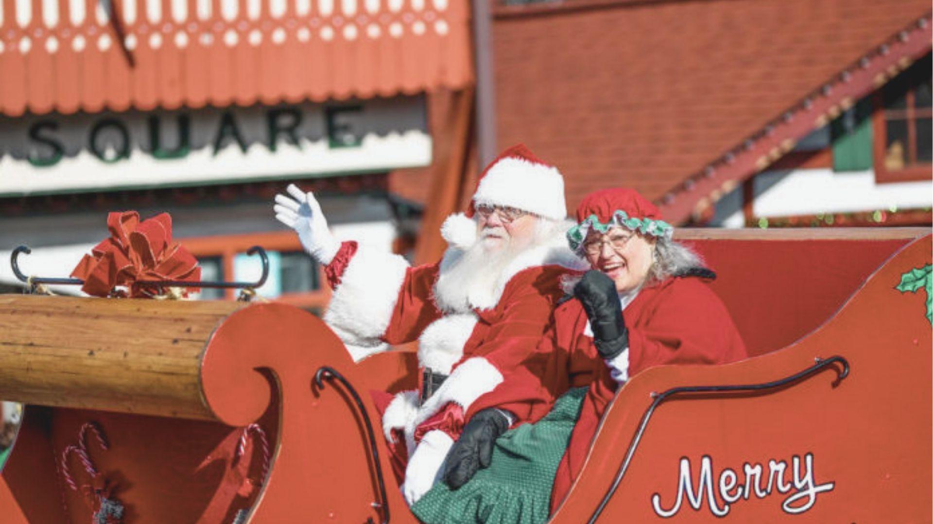 Santa and Mrs. Claus wave from a red “Merry” sleigh float during Helen’s Christmas parade.