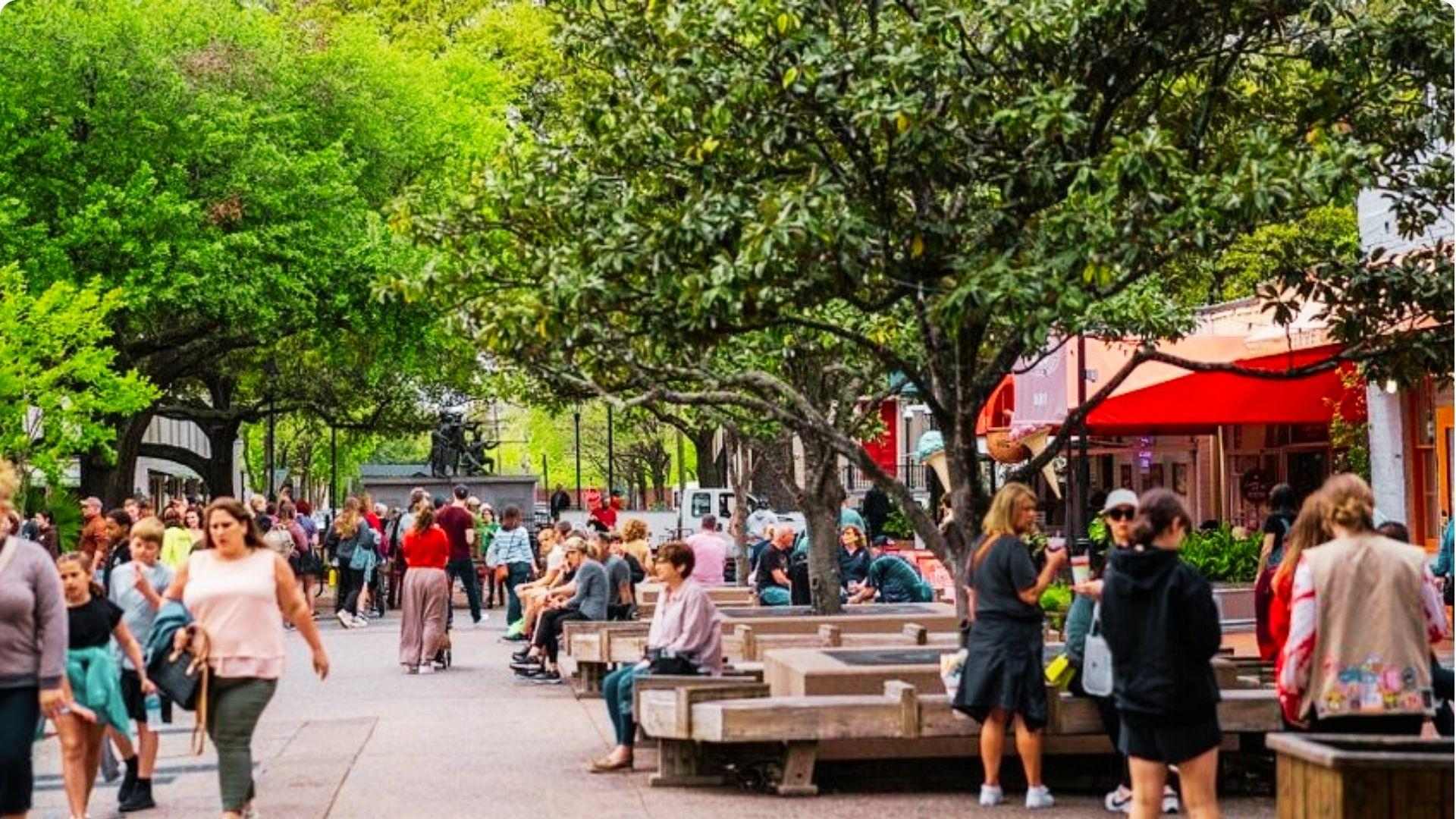 Bustling Savannah City Market with visitors strolling among shops, outdoor seating, and shaded walkways.