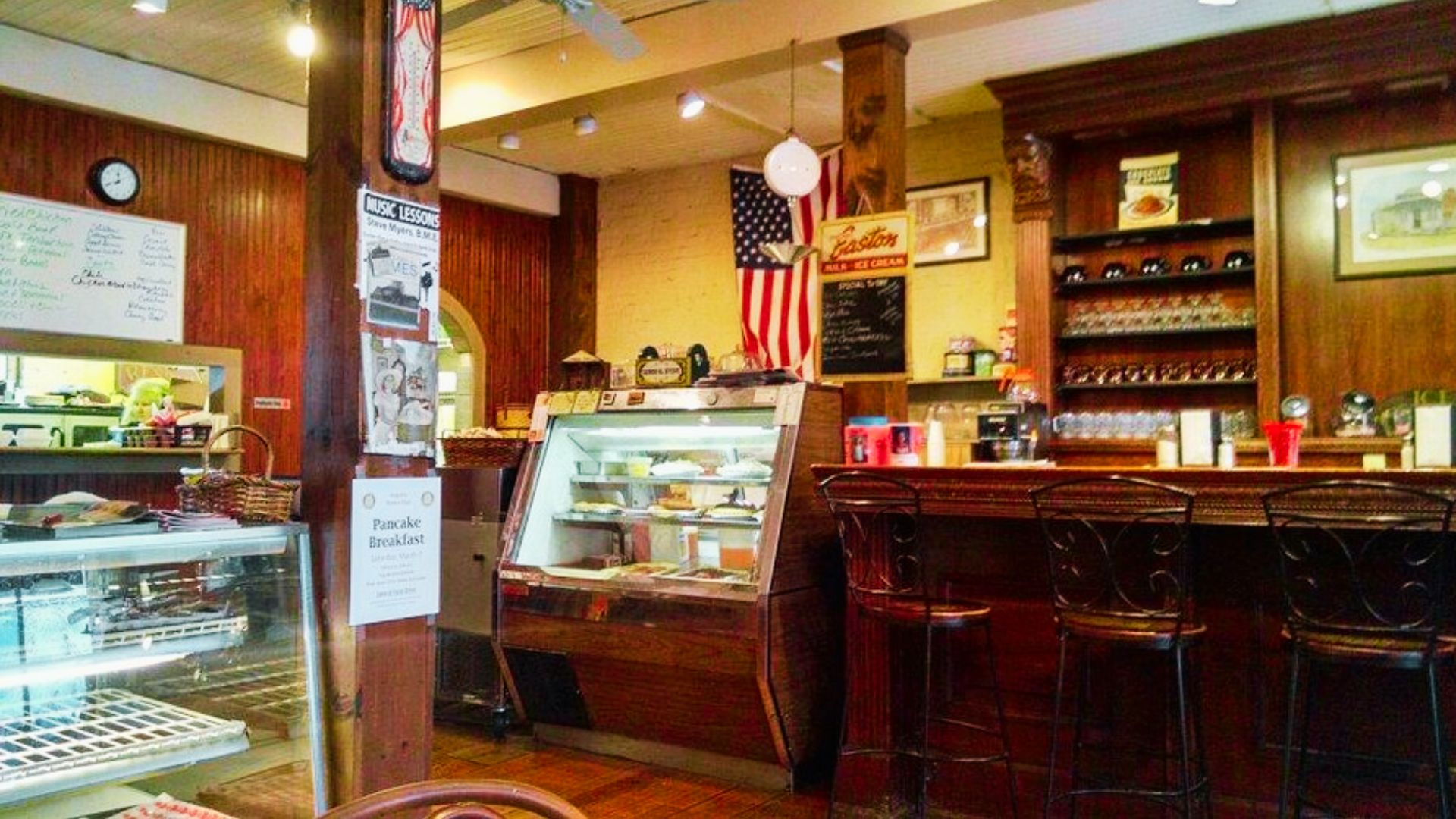 Cozy Kentucky coffee shop interior with wooden decor, dessert displays, and classic counter seating area.