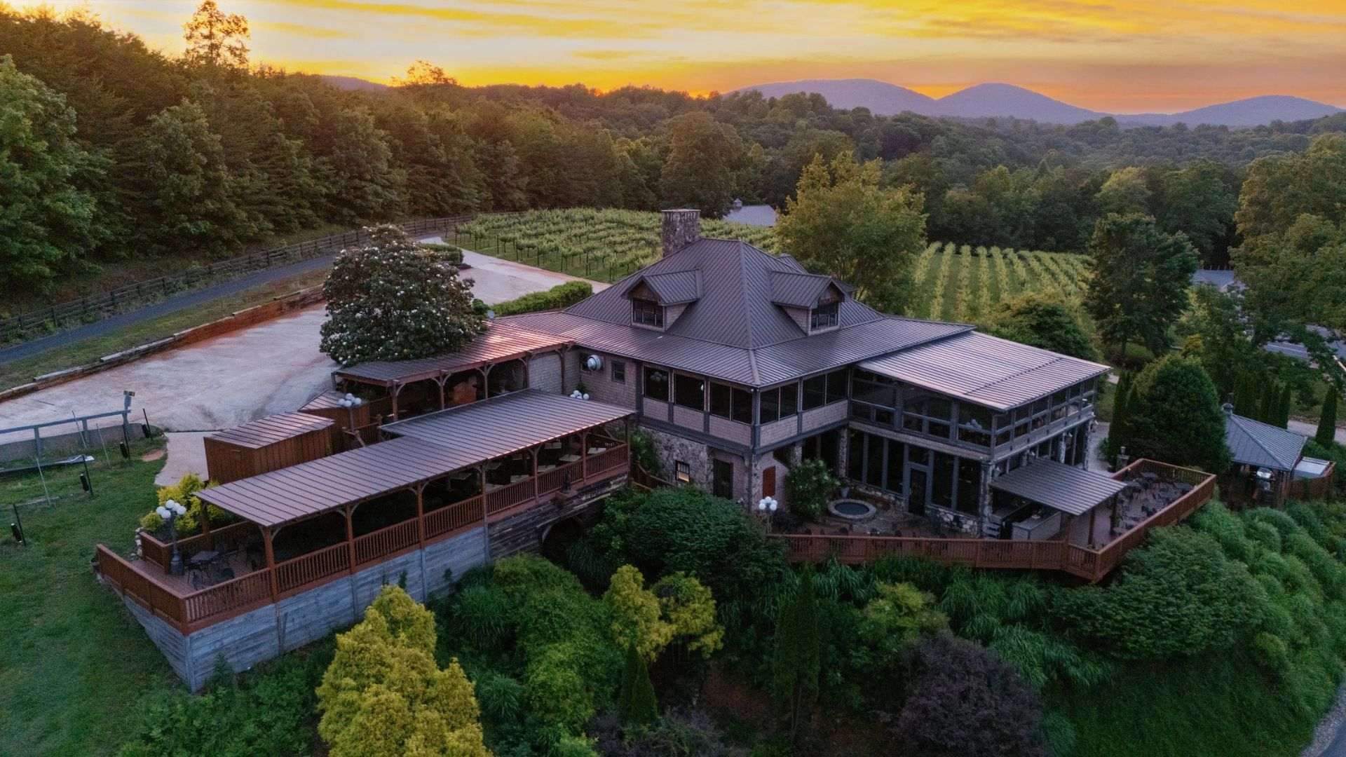 Sunset view of Wolf Mountain Vineyards and Winery home, framed by mountains in the background.