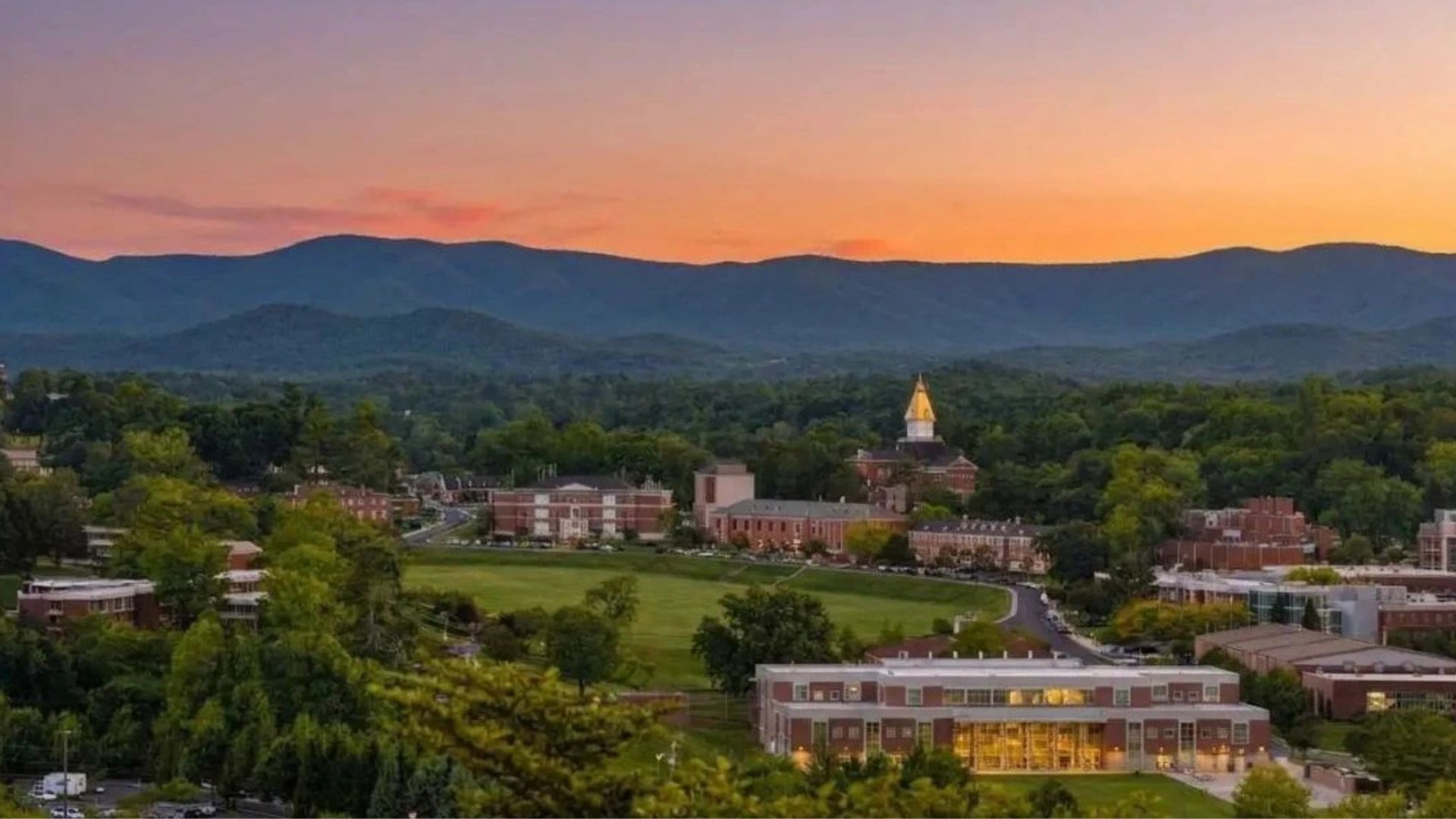 A picturesque college campus bathed in warm sunset hues, showcasing buildings and trees against a colorful sky.