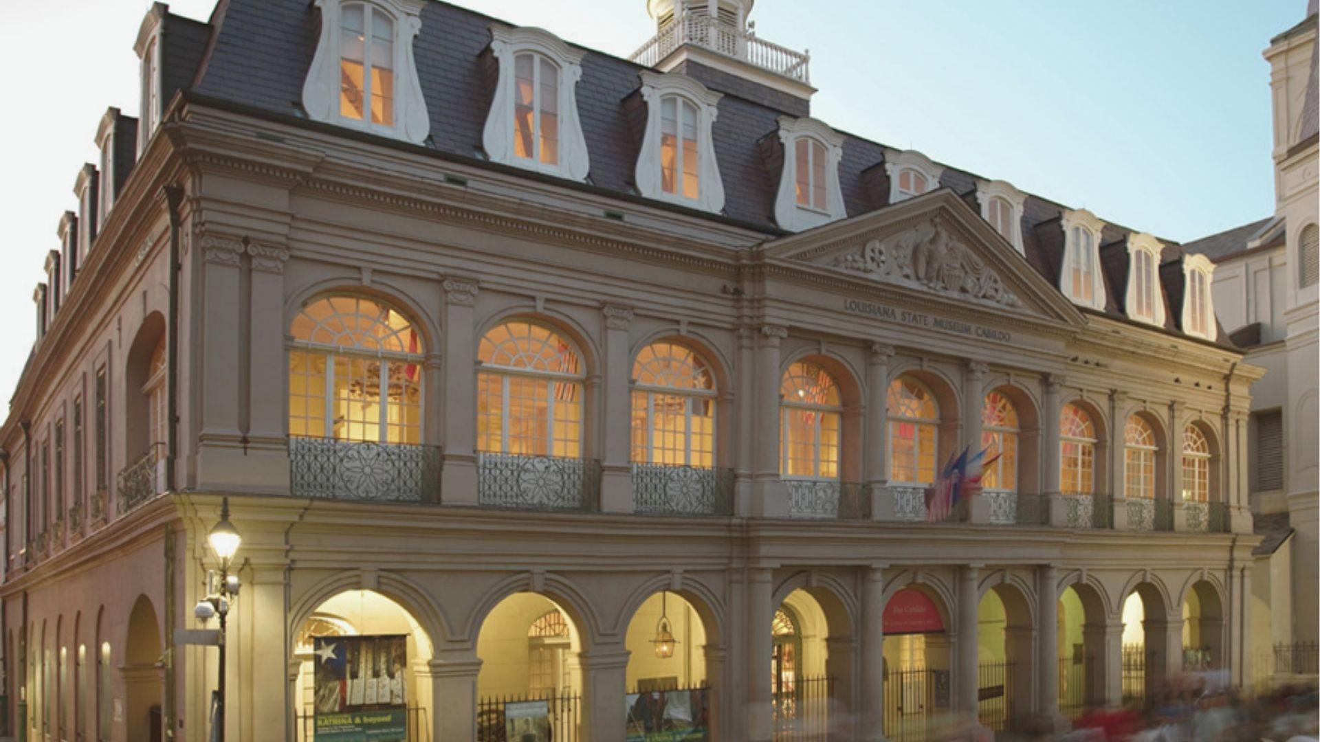 Tour the Louisiana State Museum Cabildo at dusk as its arched windows glow warmly.