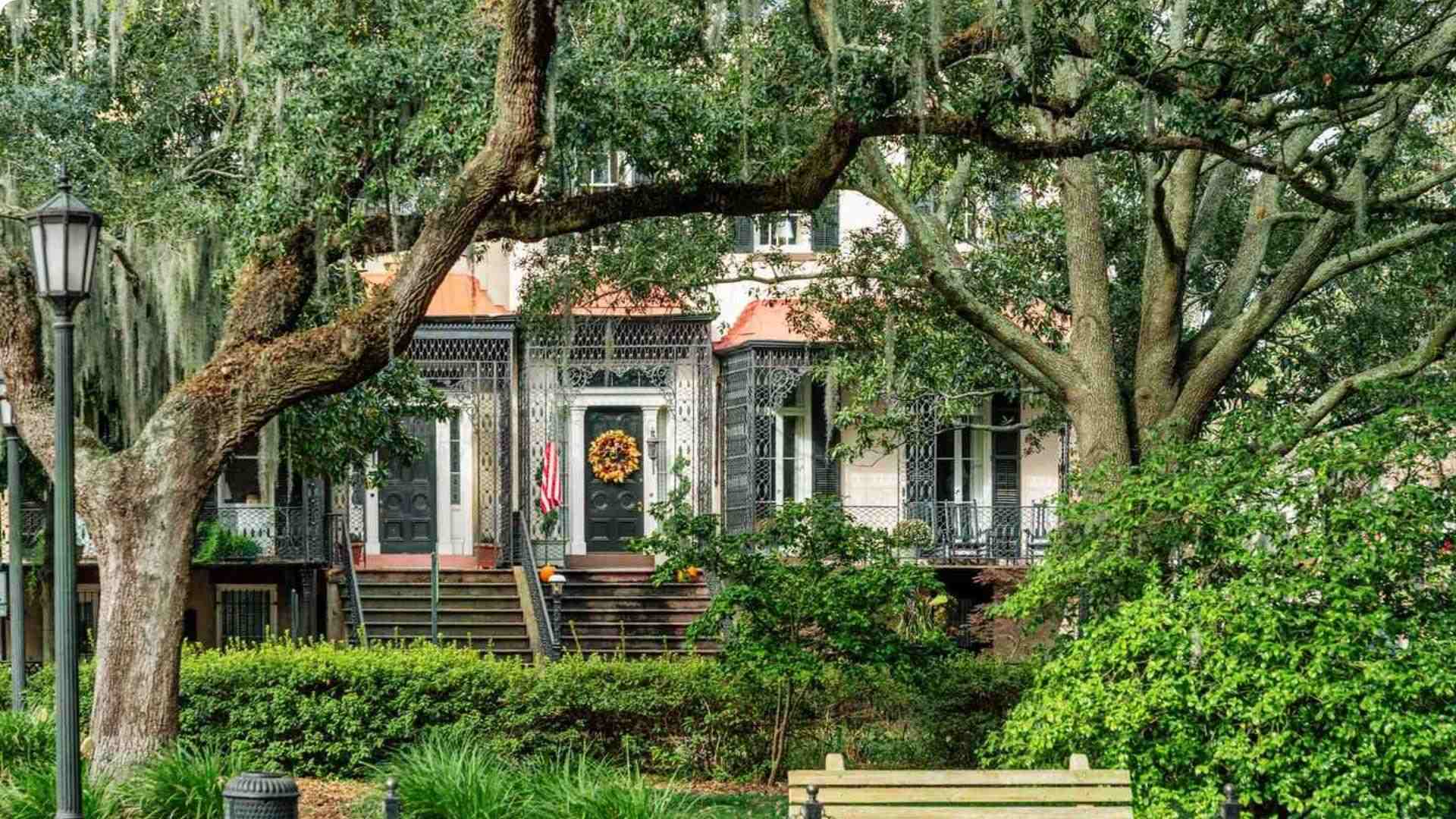 Historic Savannah townhouse with fall wreath, ironwork porch and mossy live oaks