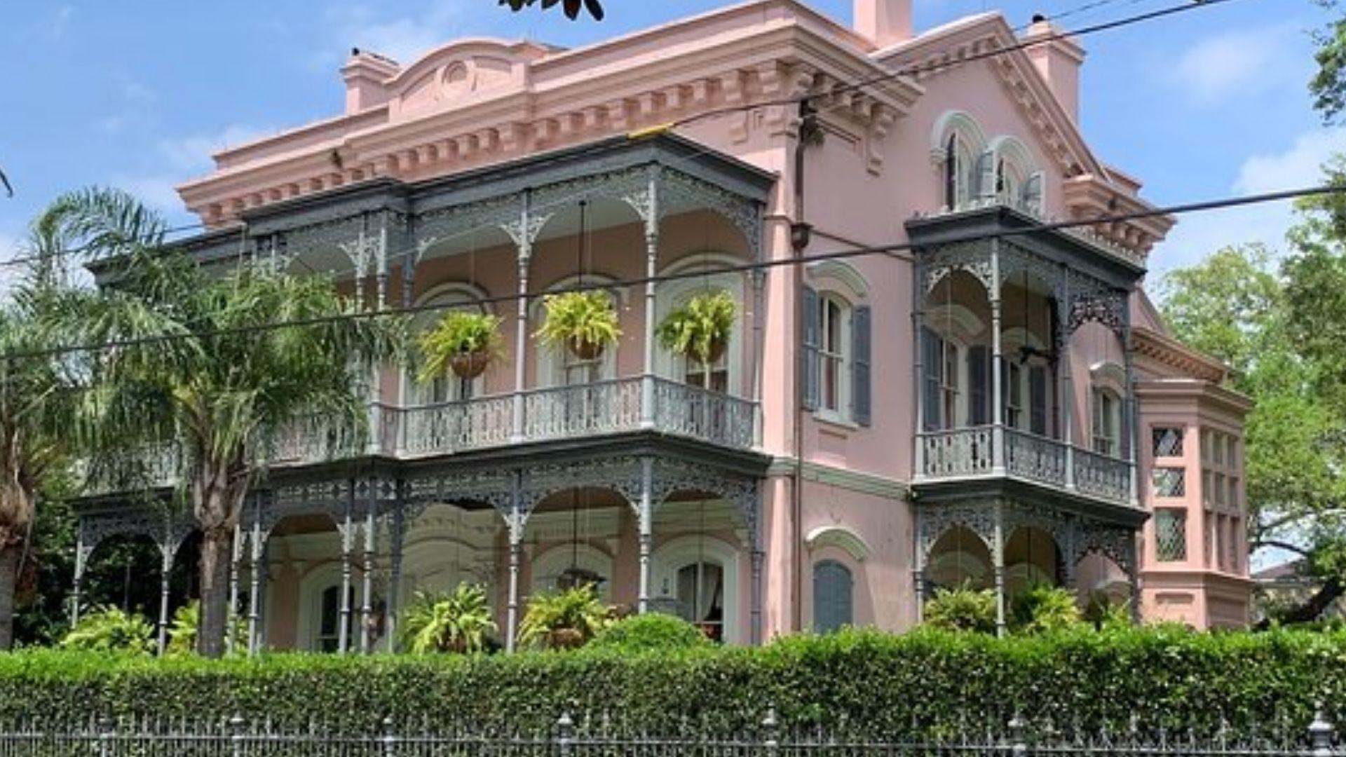 Historic pink Victorian mansion with iron balconies in New Orleans Garden District