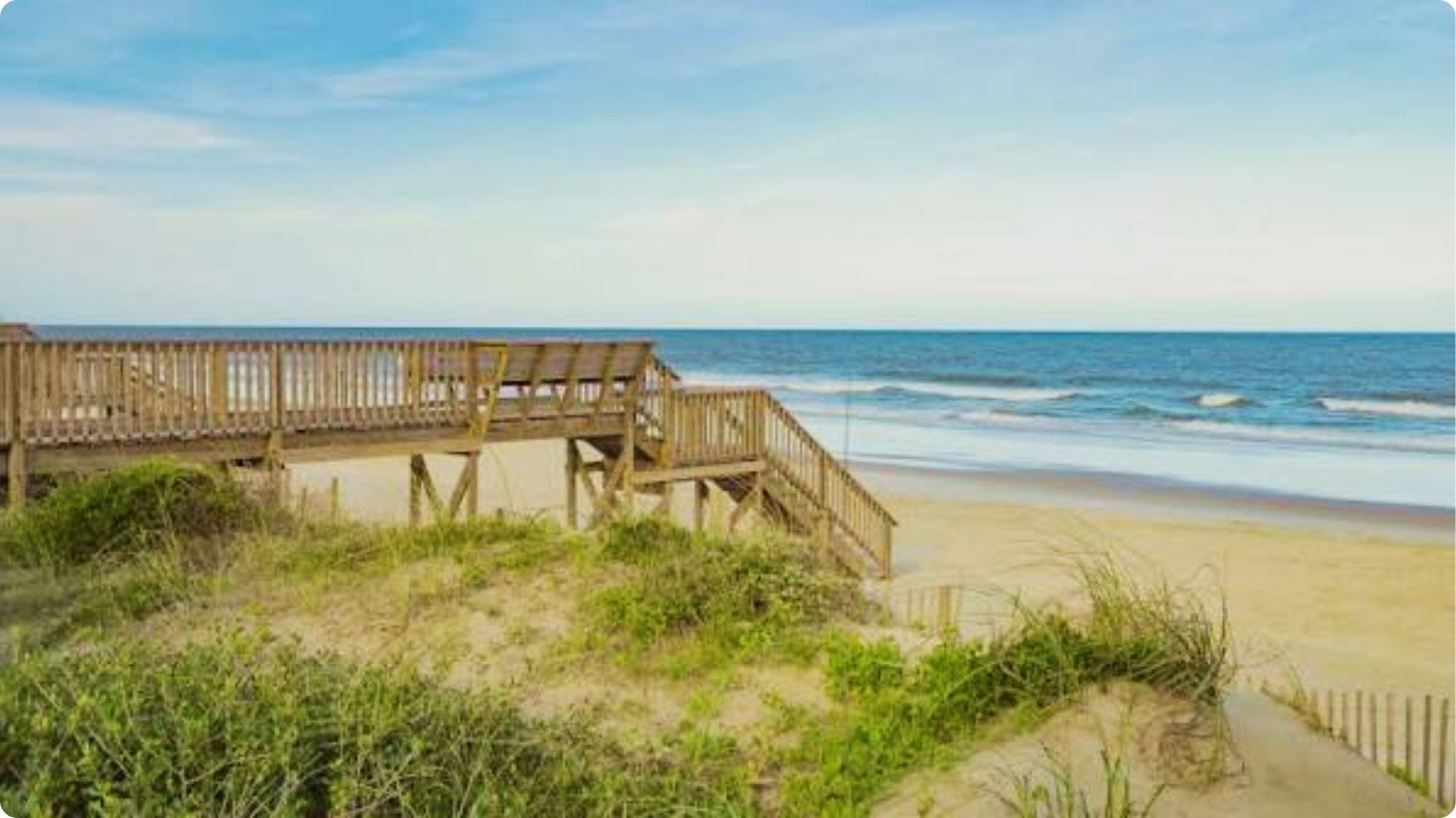 Wooden boardwalk stairs over dunes to sandy beach and ocean waves, romantic Myrtle Beach walk