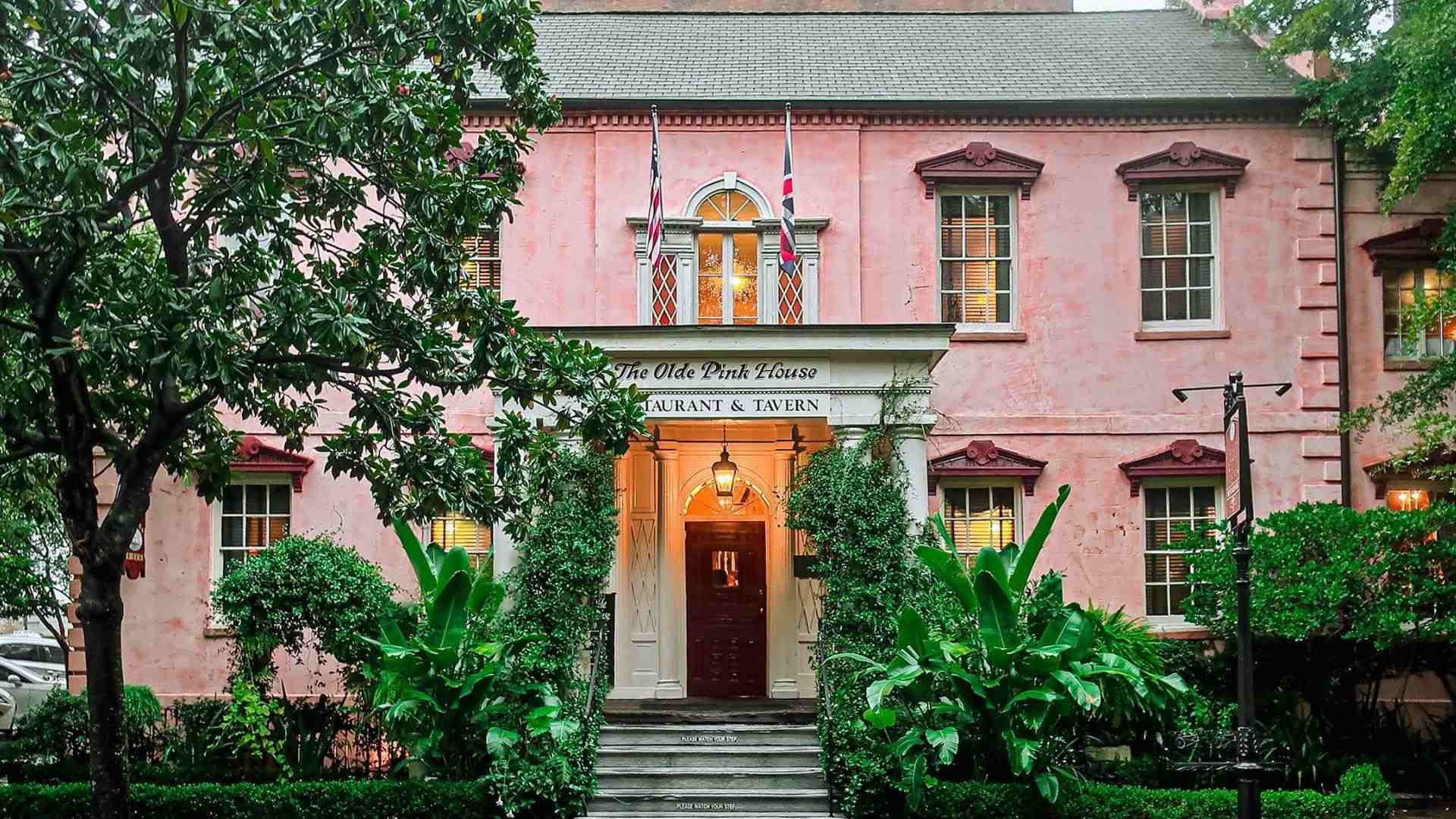 Pink historic mansion with white columns and black shutters in Savannah