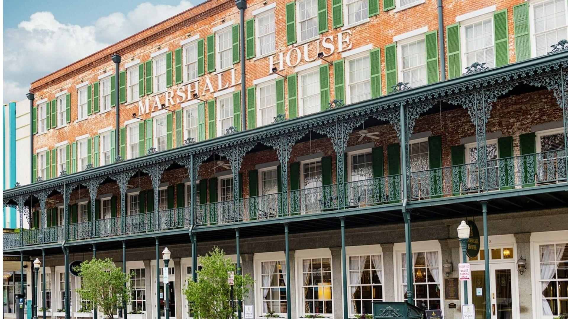 Historic Marshall House hotel in Savannah with green shutters and wrought iron balcony