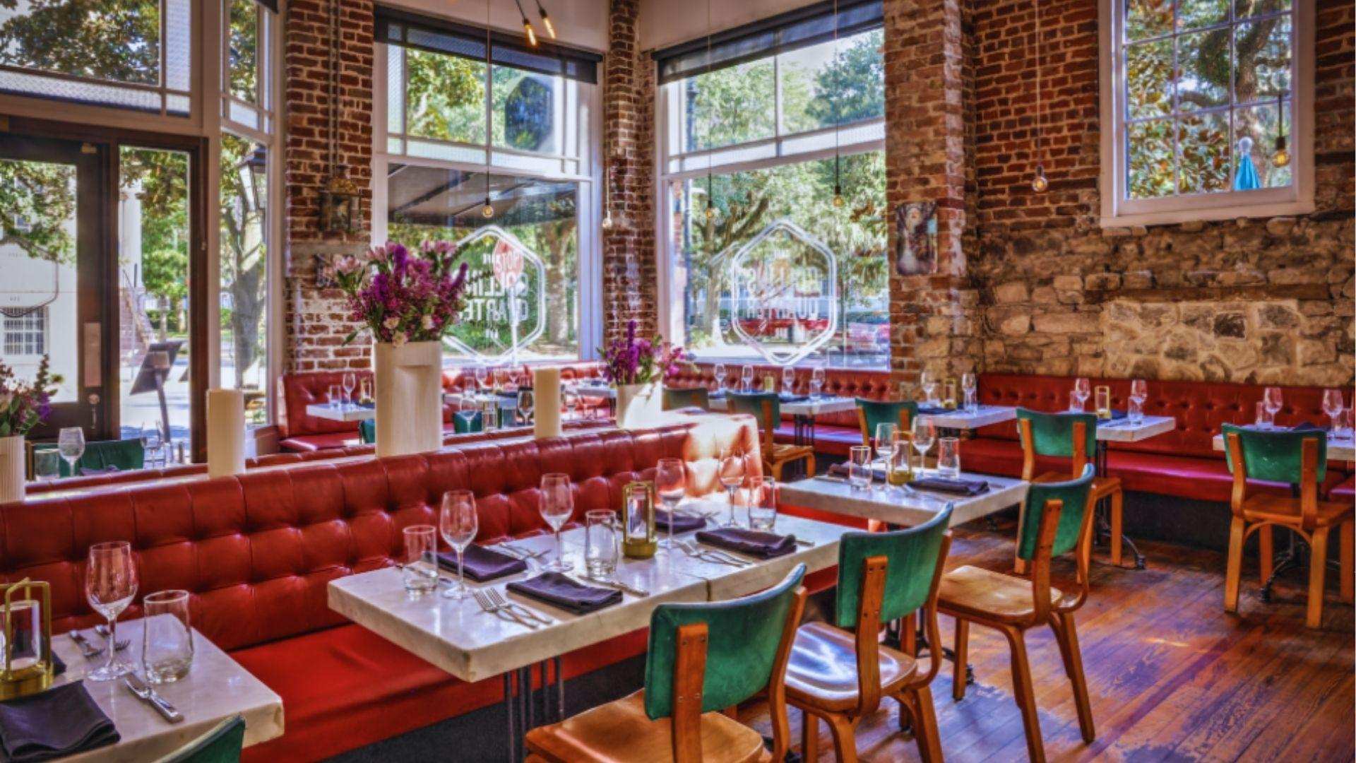 Elegant brick restaurant interior with red leather booths marble tables green chairs floral centerpieces today.