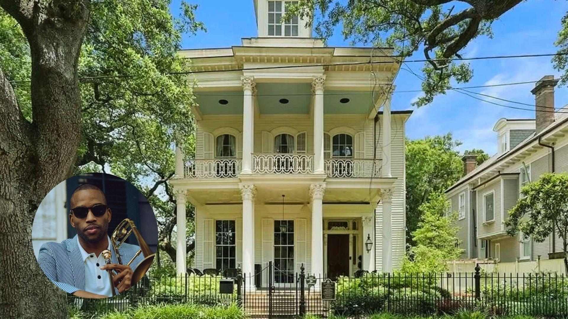 Two-story white historic house with tall columns and balconies behind an iron fence.