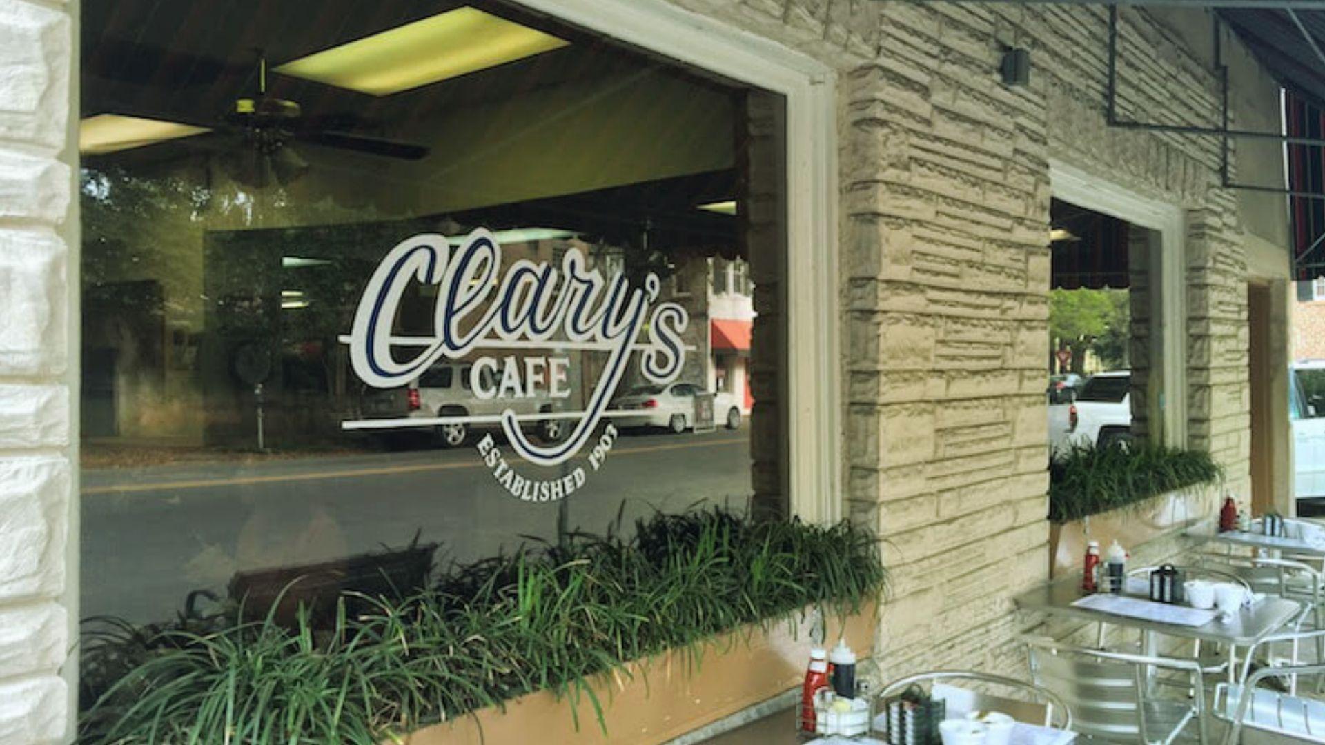 Clary's Cafe storefront window established 1907 with outdoor tables, condiments, and window box plants.